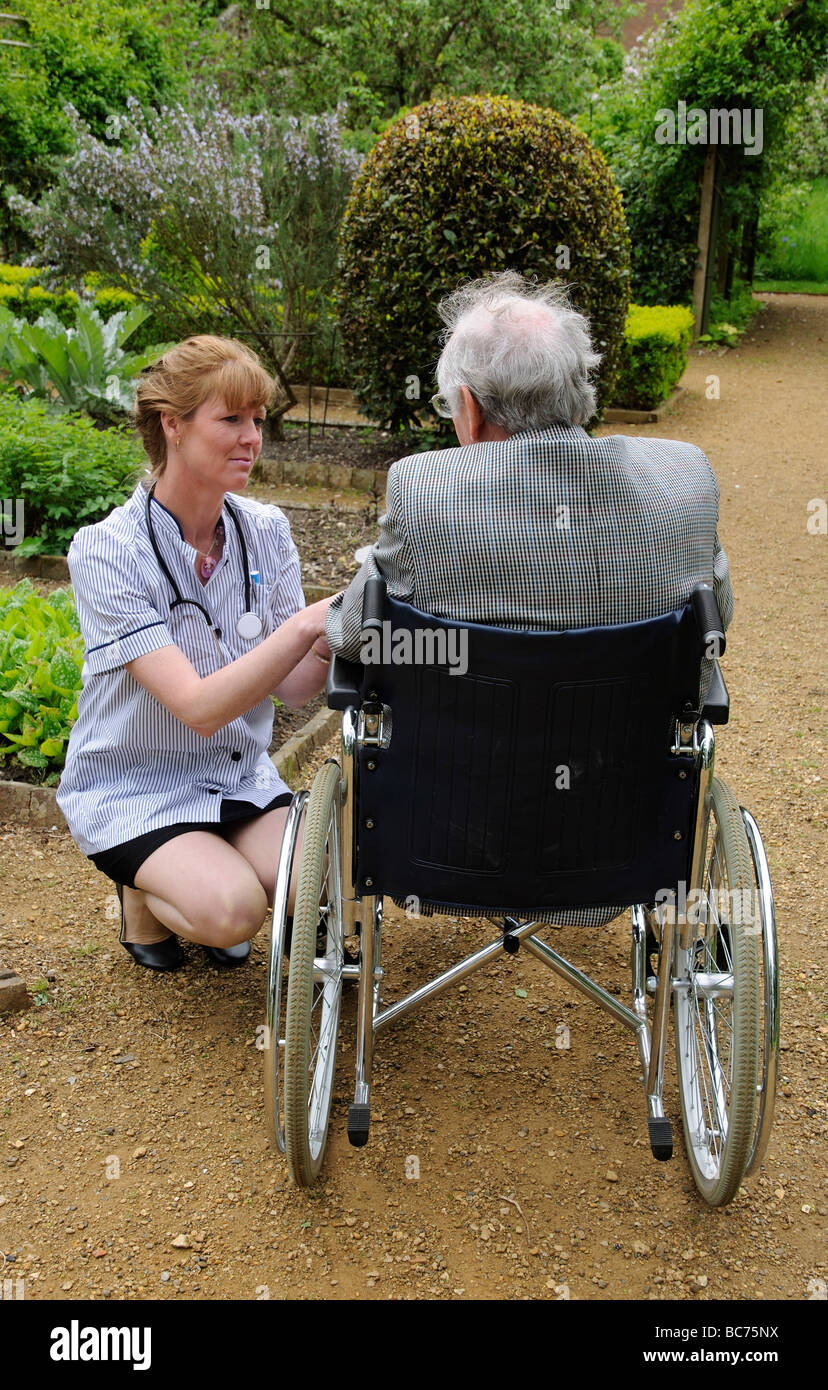 Krankenschwester Pfleger Teilnahme an älteren männlichen Patienten im Rollstuhl Stockfoto