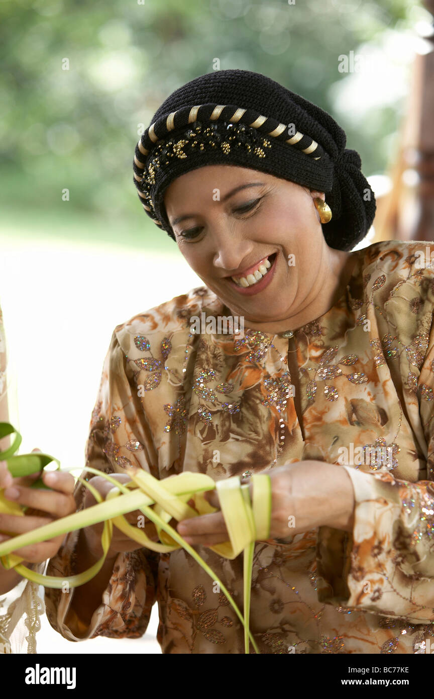 Frau konzentrieren Weberei Ketupat für die raya Stockfoto