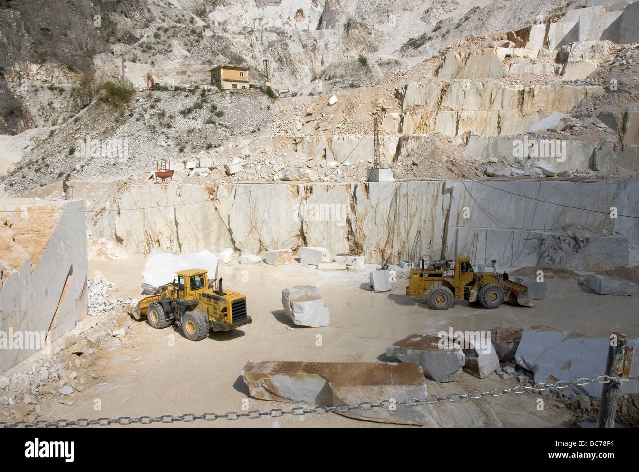 Riesige Erdbewegungsmaschinen in den Schatten gestellt durch die Größe des Marmor-Steinbruch in Carrara Stockfoto