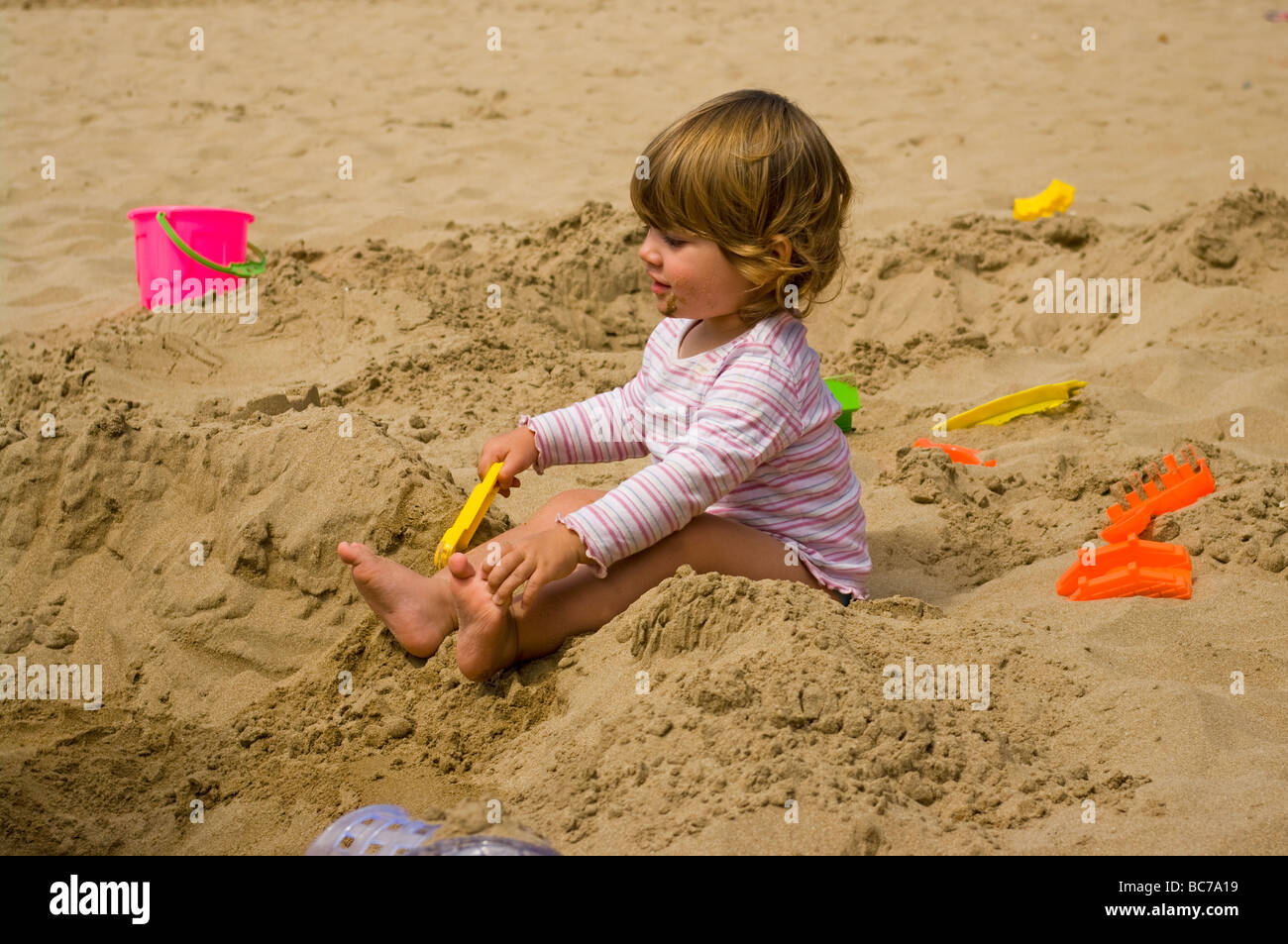Babymädchen spielen im Sand am Strand Stockfotografie - Alamy