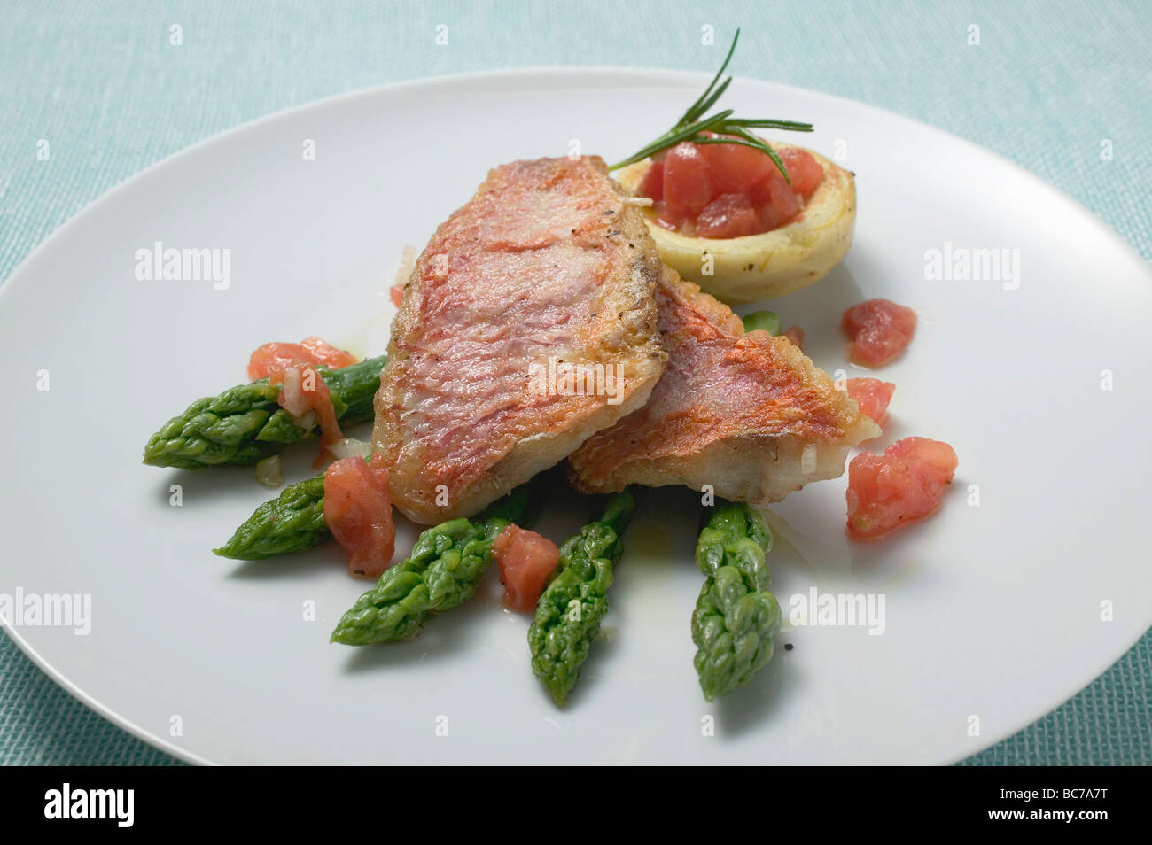 Gebratene Rotbarbe Filets mit Spargel und Tomaten- Stockfoto