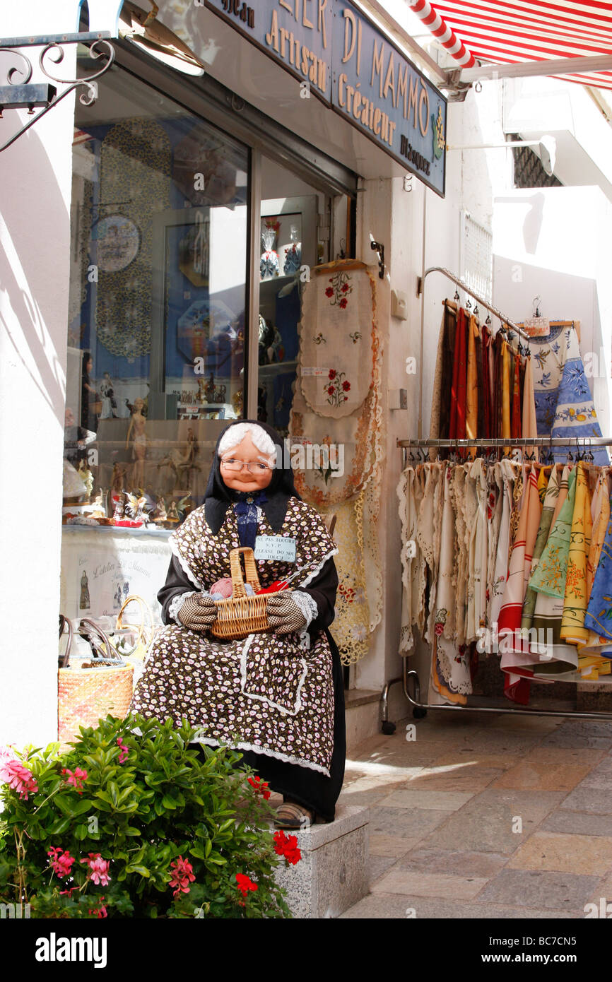 Modell einer alten Frau mit einem Korb sitzt außerhalb ein Souvenirladen in Calvi, Korsika, Frankreich Stockfoto