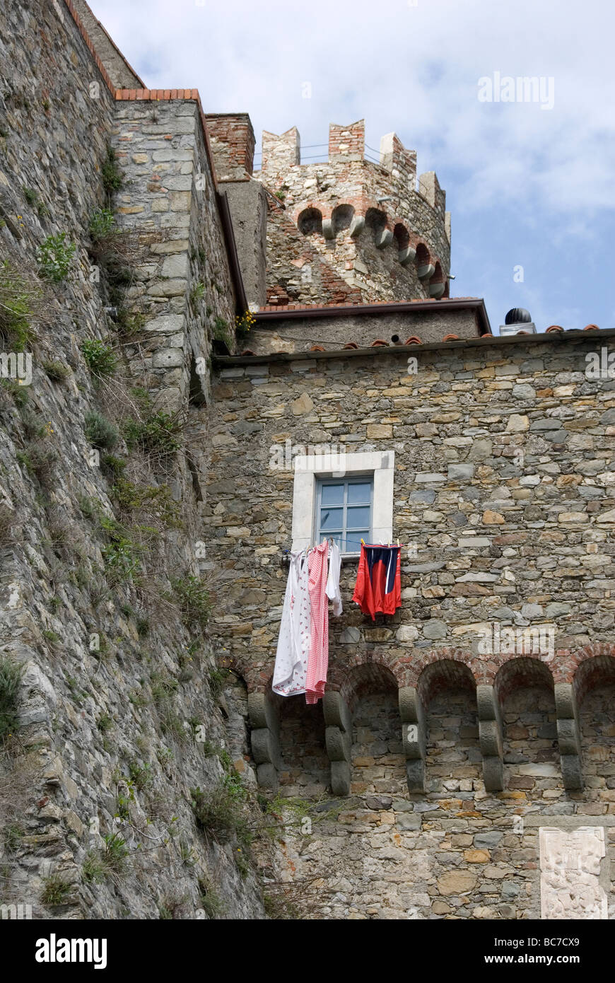 Gegenüberstellung der täglichen Wäsche hängen aus dem Fenster einer massiven mittelalterlichen Burg, die Jahrhunderte alt ist Stockfoto