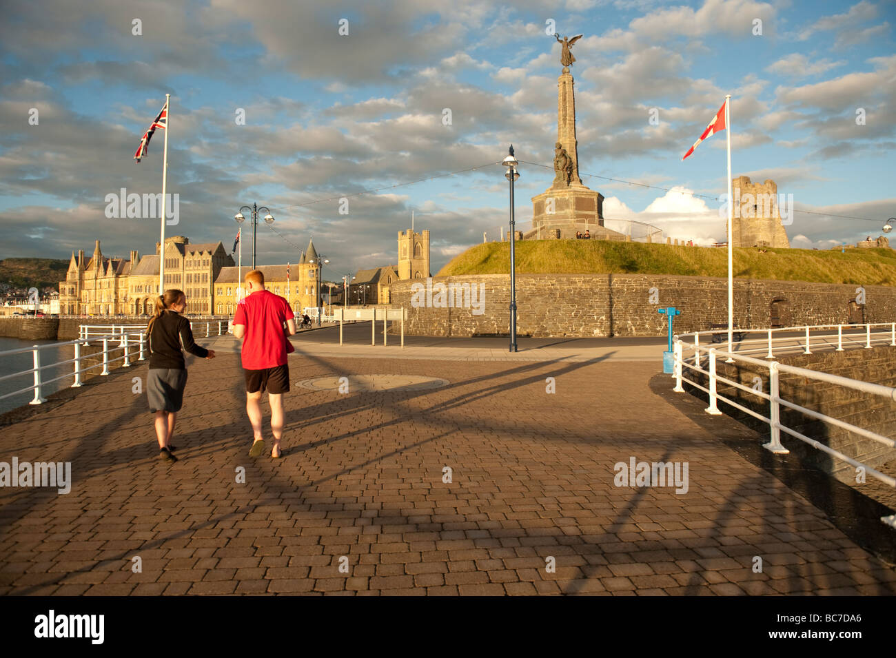 zwei Personen auf Aberystwyth promenade mit Kriegerdenkmal University und Schloss Sommer Abend Wales UK Stockfoto