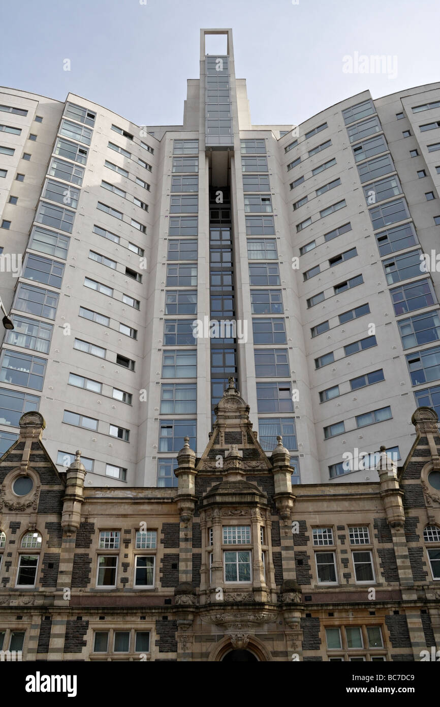 Der Altolusso-Turm im Zentrum von Cardiff, Wales, Großbritannien, über der Fassade des alten Wohnhauses des New College in der Innenstadt. Hoher Hochhausblock Stockfoto