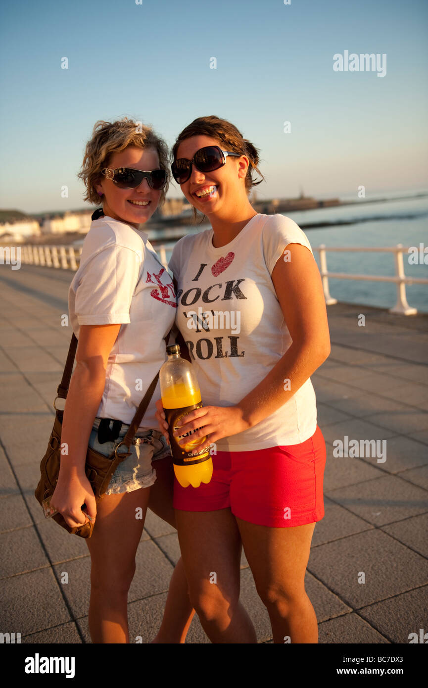 Zwei attraktive glücklich lächelnde junge Frauen Studentinnen Aberystwyth promenade Sommer Abend Wales UK Stockfoto