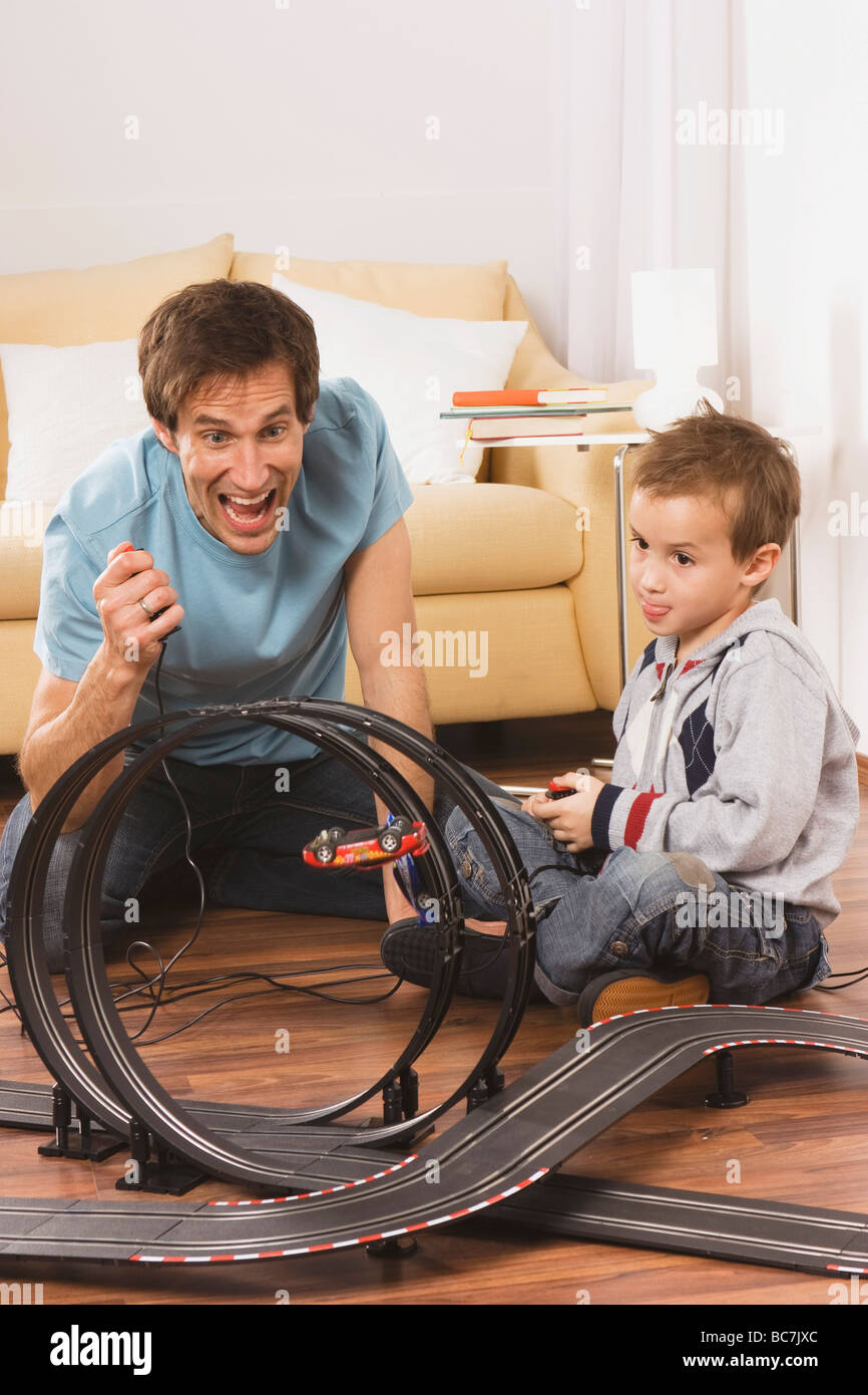 Vater und Sohn (4-5) spielen mit Spielzeug-Rennbahn Stockfoto