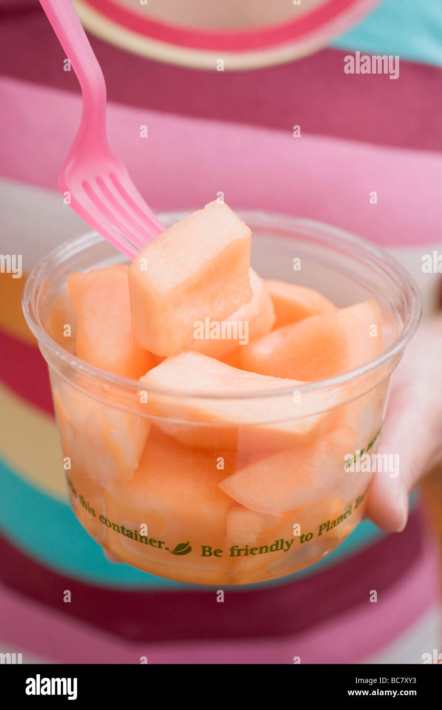Frau Essen gewürfelte Melone aus Kunststoff-Wanne- Stockfoto