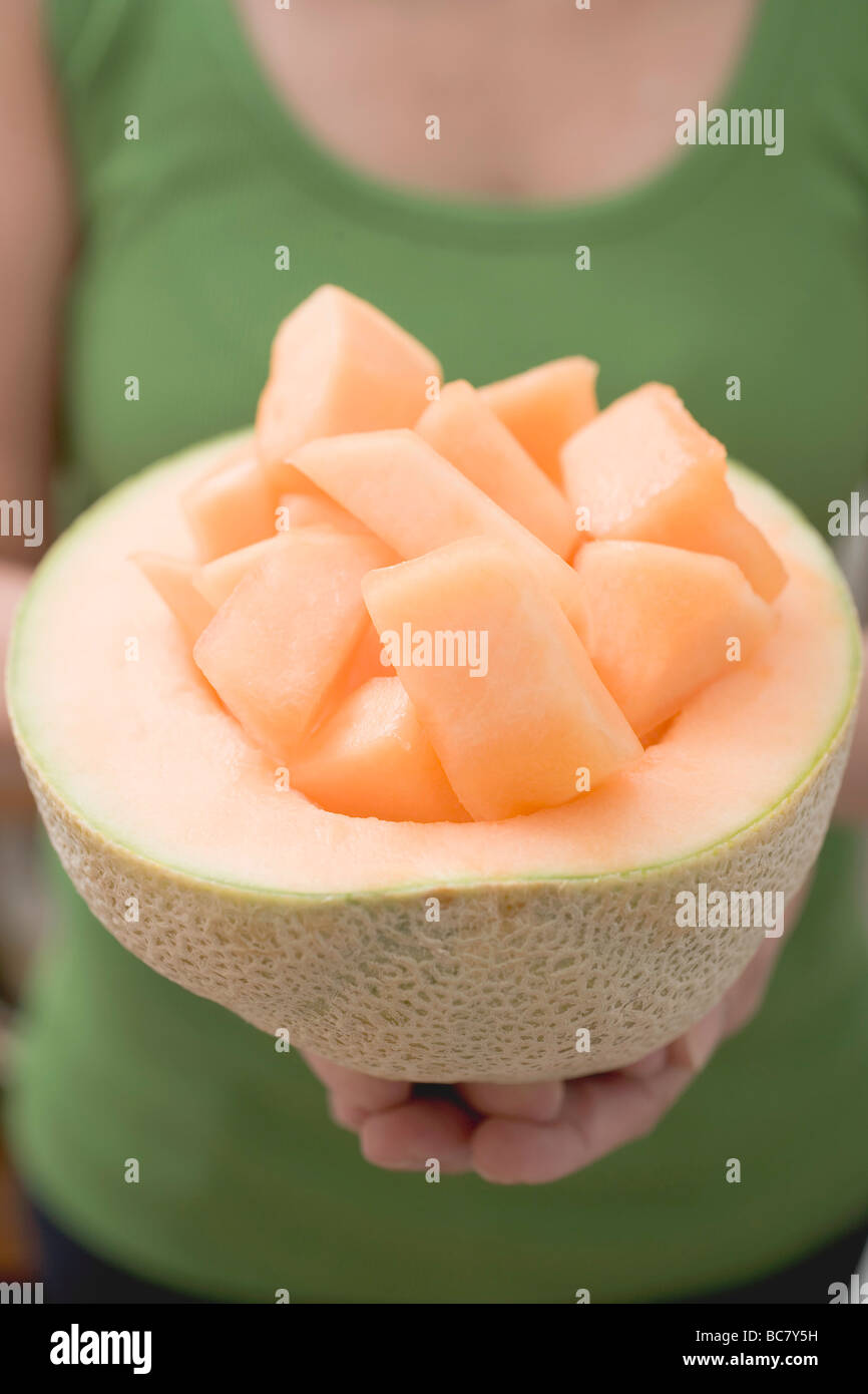 Frau mit gewürfelt in ausgehöhlte Melone Melone Melone- Stockfoto