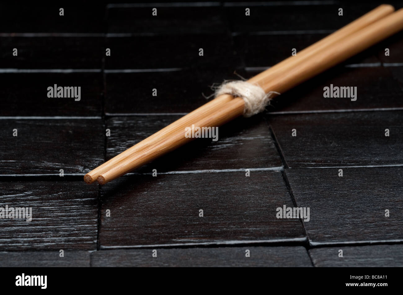 eine horizontale Nahaufnahme von Stäbchen auf einem schwarzen Hintergrund aus Holz Stockfoto
