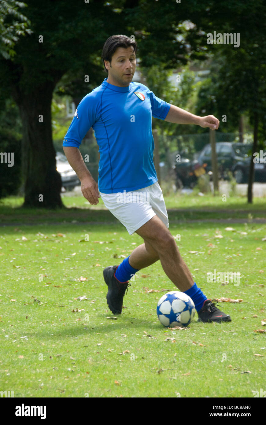 Fußballer im Park einen Ball dribbeln Stockfoto