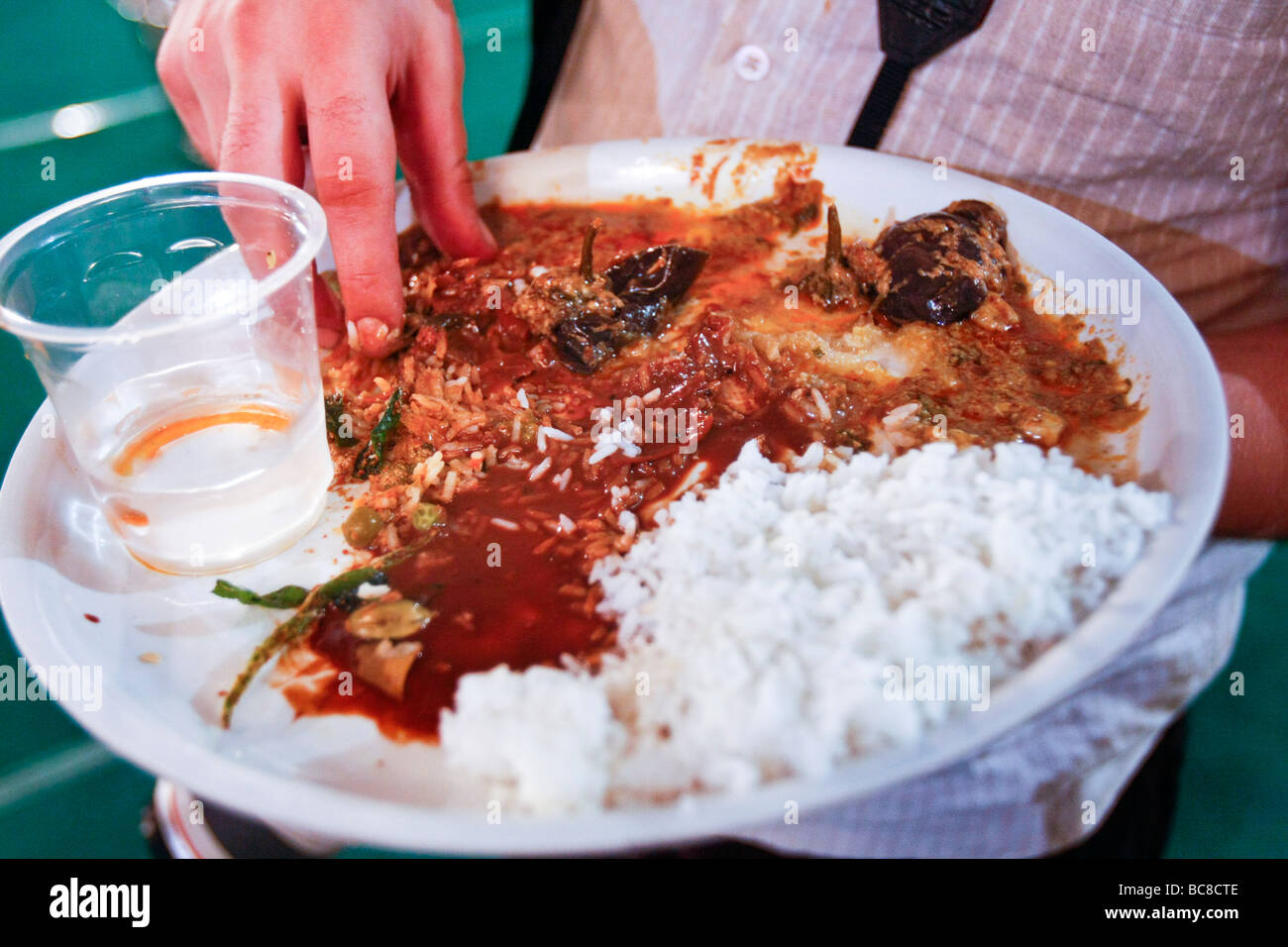 Ein Westler isst ein indisches Essen direkt mit seinen Händen in die traditionelle südindische Art. Stockfoto