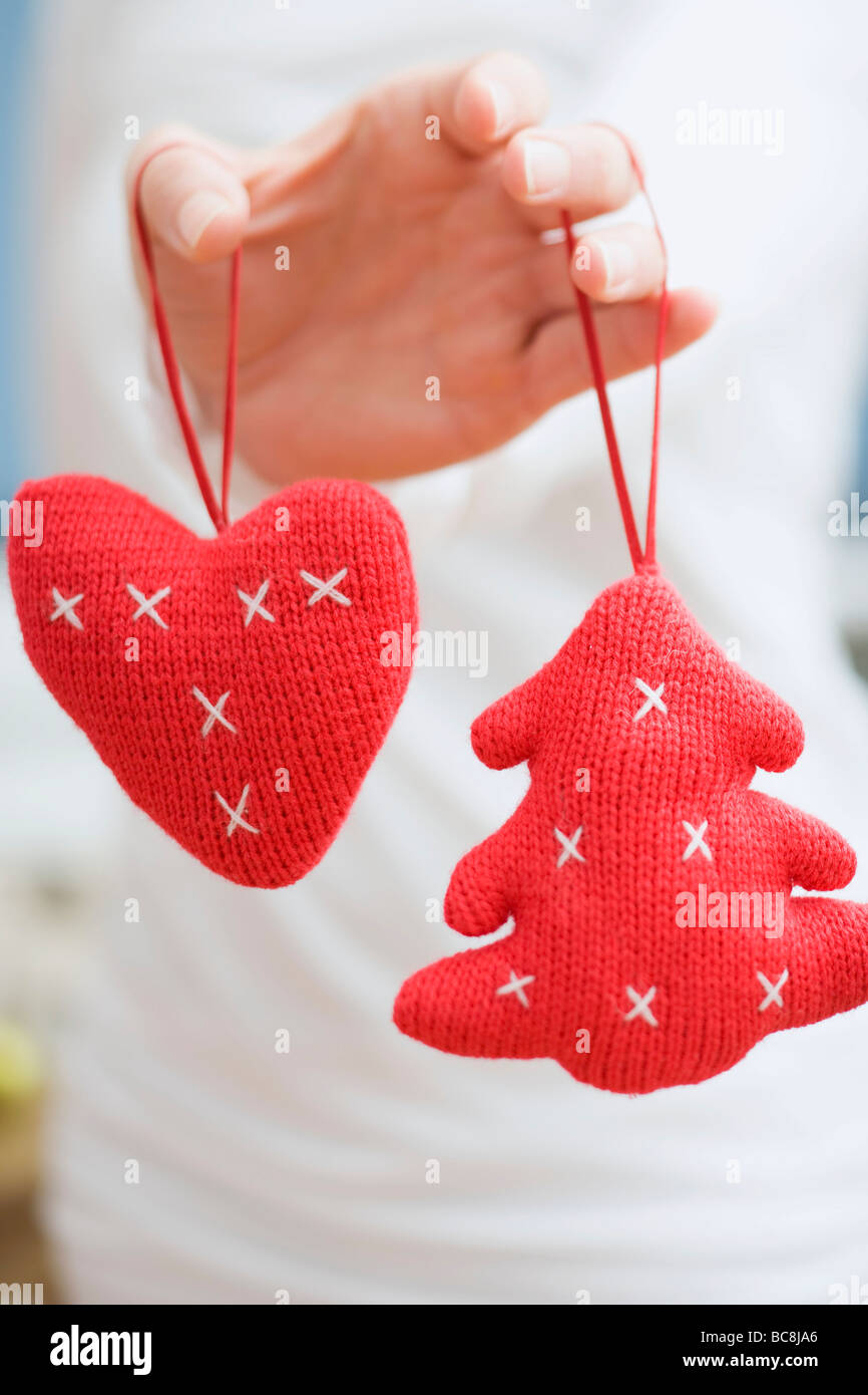 Hand halten zwei gestrickte Christbaumschmuck- Stockfoto