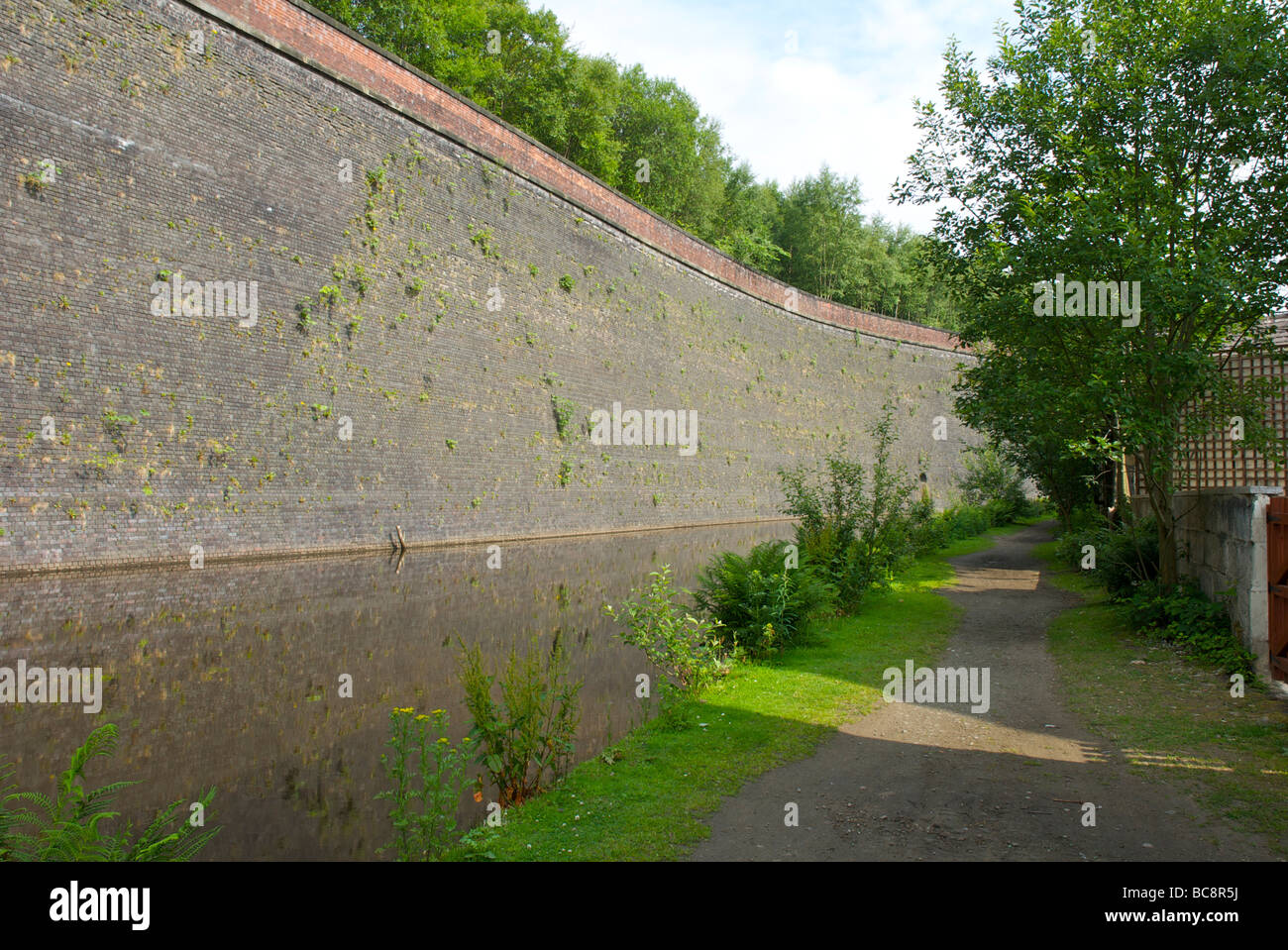 Die große Mauer von Todmorden: Stützmauer, Eisenbahnlinie über den Rochdale Kanal, West Yorkshire, England UK zu unterstützen Stockfoto