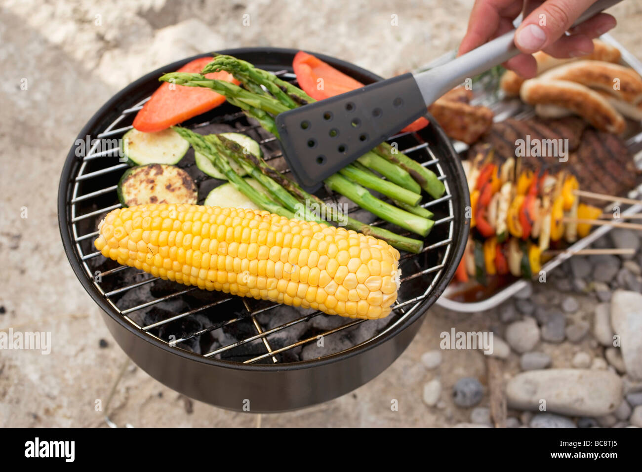 Hand drehen auf Grill mit Grillzange Spargel- Stockfoto