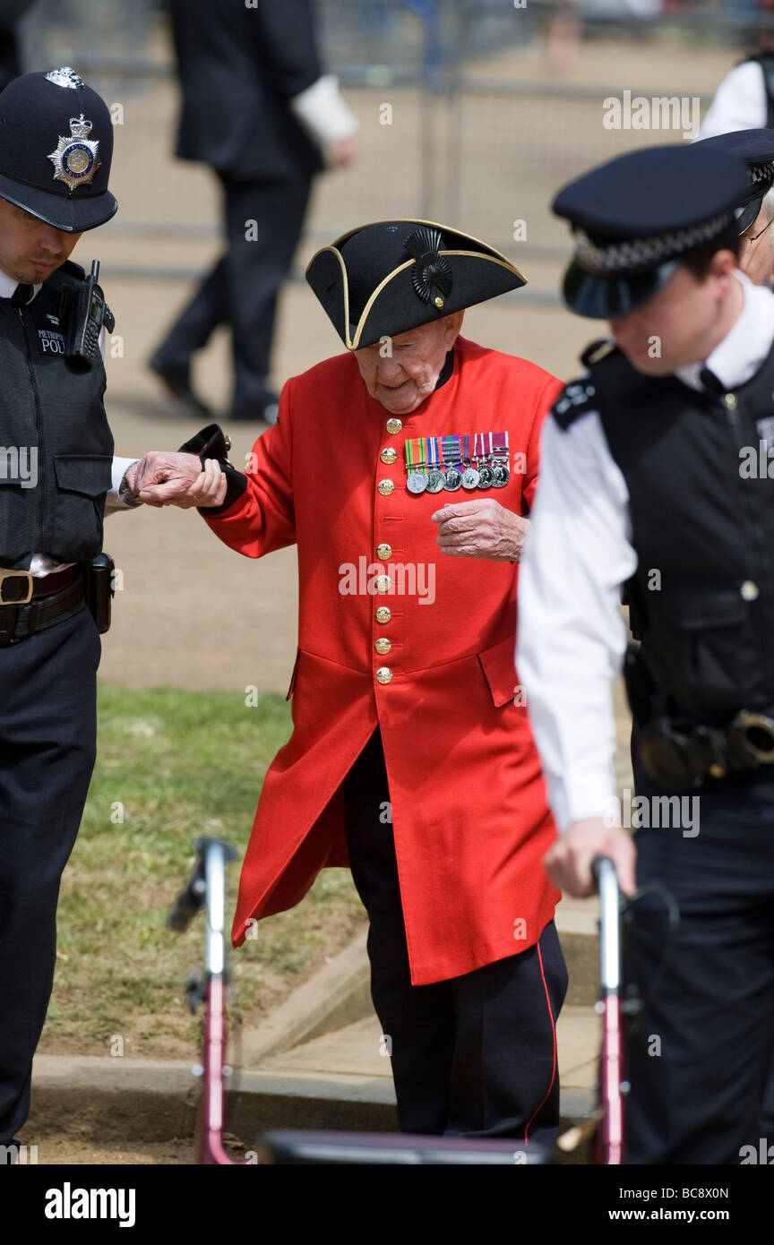 Eine Frai half Chelsea Pensionär von Polizisten auf der kombiniert Kavallerie alte Kameraden Vereinigung Parade in London Hyde Park Stockfoto