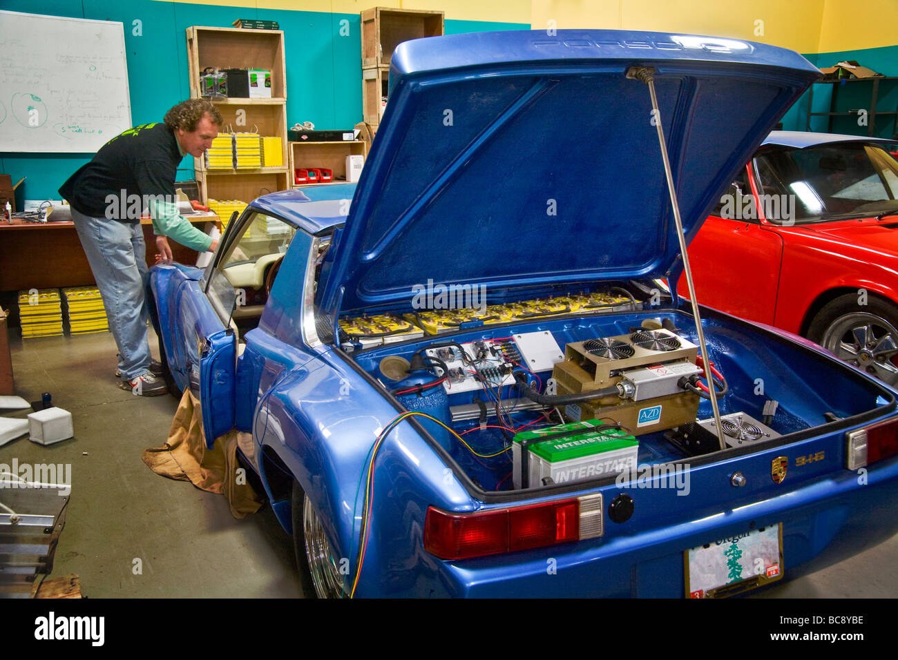 Ein Techniker in einem California Fahrzeug Modifikation Shop installiert 335 Volt DC Lithium Eisen Phosphat-Batterie in einem Porsche-Auto Stockfoto