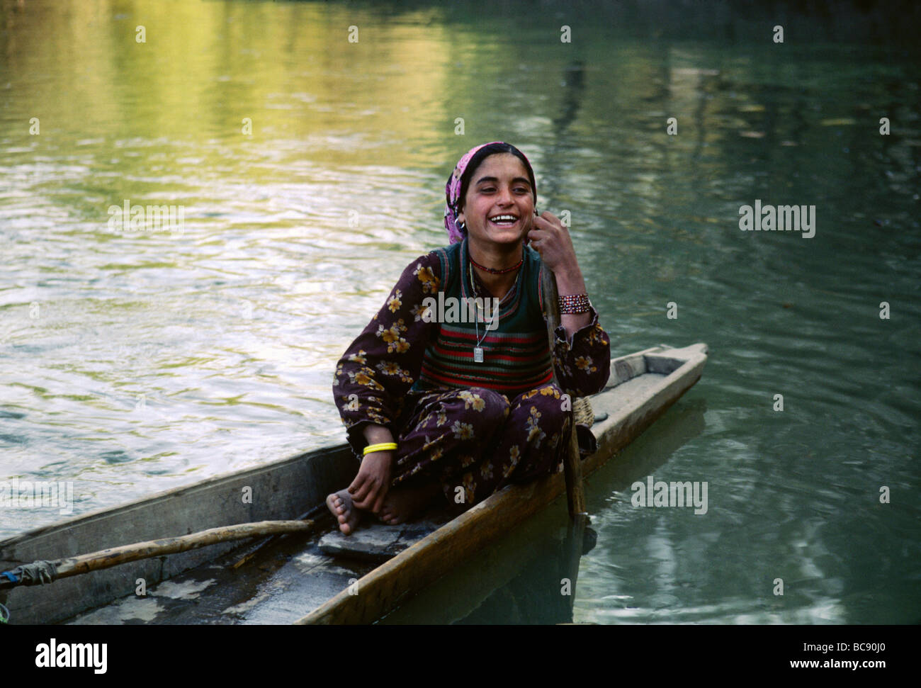 Schöne KASHMIRI Mädchen sitzt auf der Rückseite ein hölzernes Kanu auf den WULAR See Kaschmir Indien Stockfoto