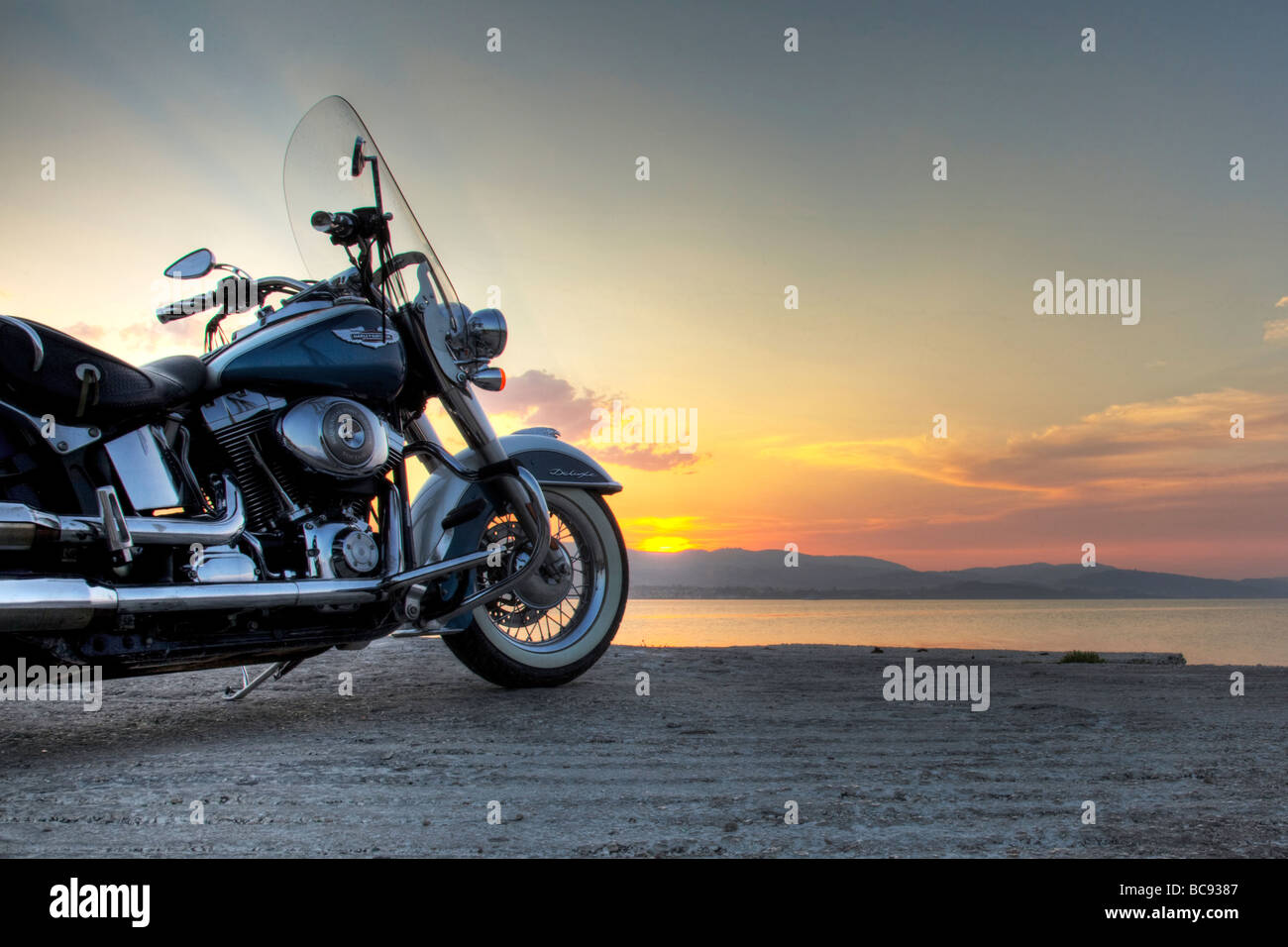 Ein Harley Davidson Motorrad Motorrad unter in den Sonnenuntergang, wenn die Sonne am Tag untergeht Stockfoto