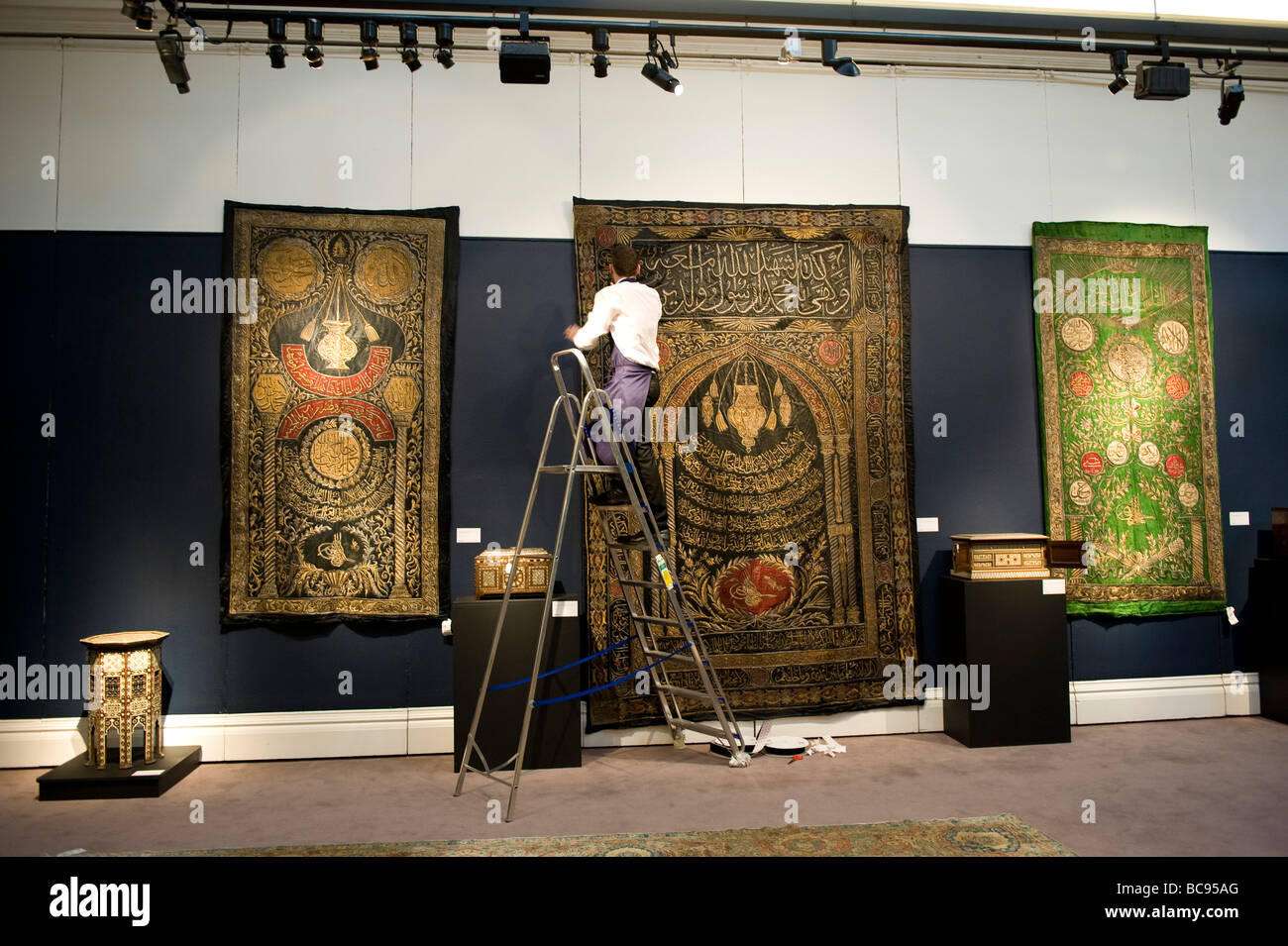 Vorbereitung der Orientteppiche Display an der London Sothebys "Arts of the Islamic World" Verkauf Stockfoto