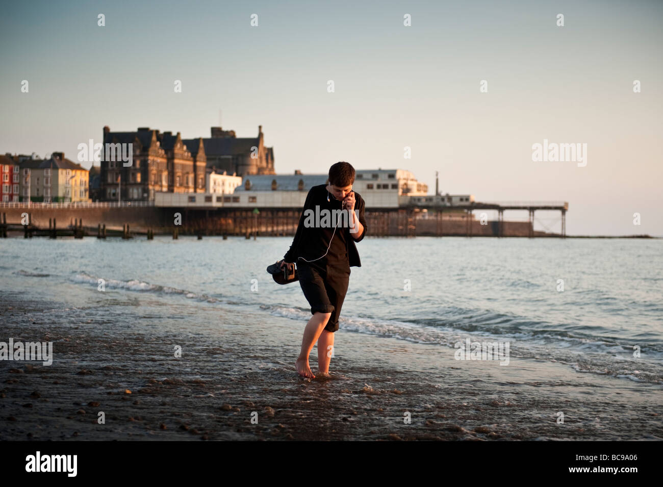 Eine junge Frau, Paddeln, Wandern im Meer Aberystwyth Wales UK Sommerabend Stockfoto