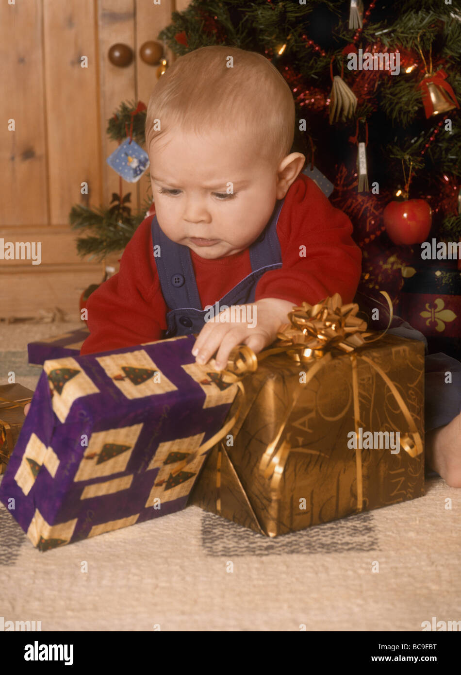 Babyjungen suchen zu Weihnachten präsentiert Stockfoto