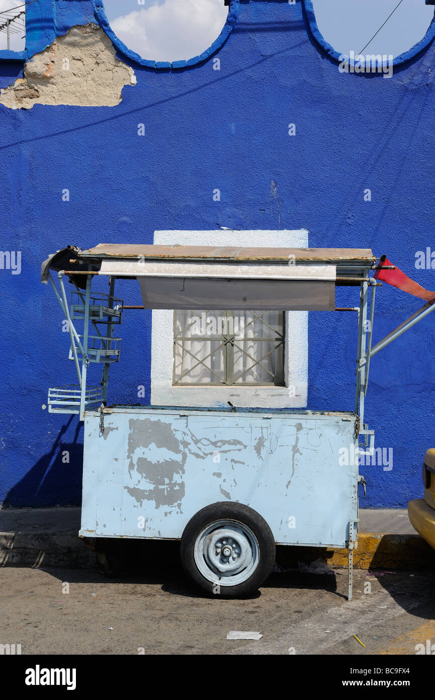 Zwei Blues - ein Lebensmittel Verkäufer Wagen durch einen tiefen blauen Wand in Tlaquepaque, Mexiko Stockfoto