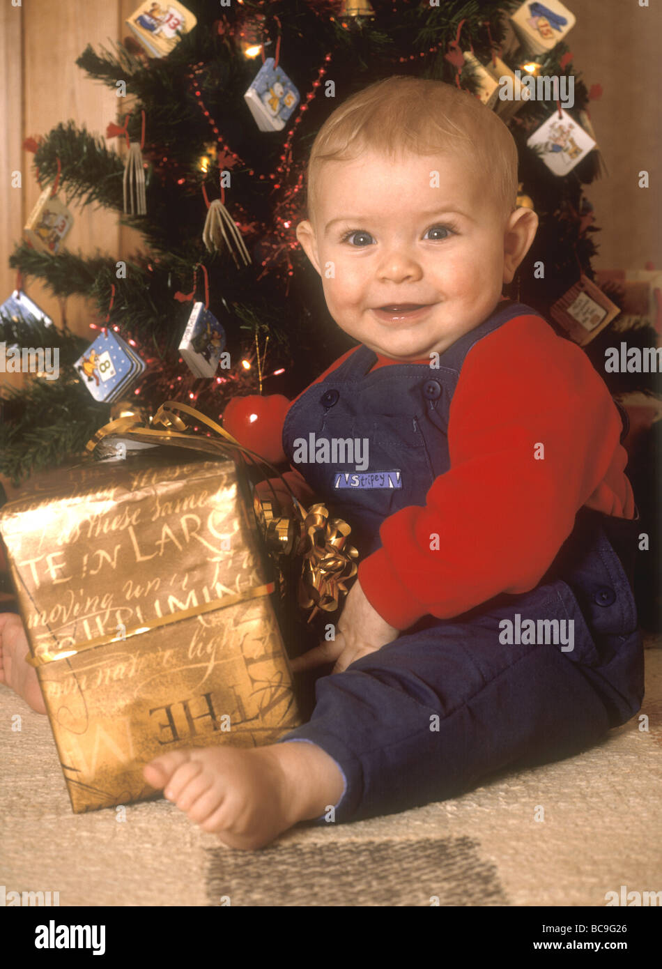 Baby Boy holding Weihnachtsgeschenk Stockfoto