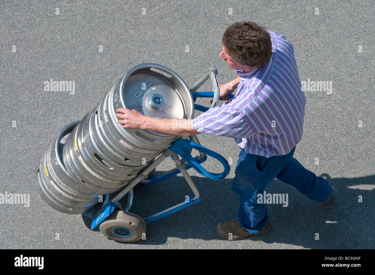 Bier Auslieferungsfahrer mit Metall Fässer auf 2-Rad-LKW - Frankreich. Stockfoto