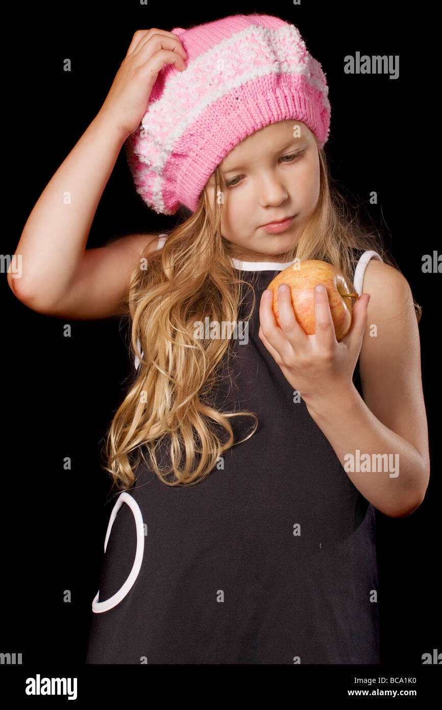 lustige nachdenklich Mädchen mit Apple in den Händen auf schwarzem Hintergrund Stockfoto