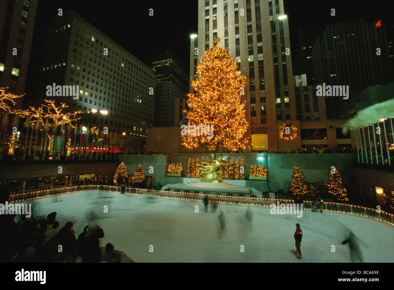 Rockefeller Center bei Nacht mit Weihnachtsschmuck, Lower Plaza mit Prometheus, Eis Menschen Tellspiele in den Vordergrund, neue Y Stockfoto