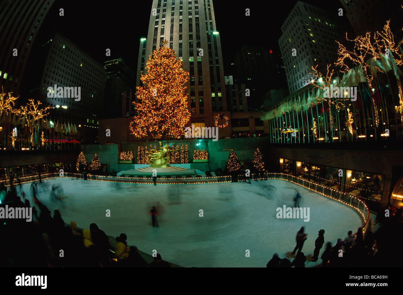 Rockefeller Center bei Nacht mit Weihnachtsschmuck, Lower Plaza mit Prometheus, Eis Menschen Tellspiele in den Vordergrund, neue Y Stockfoto