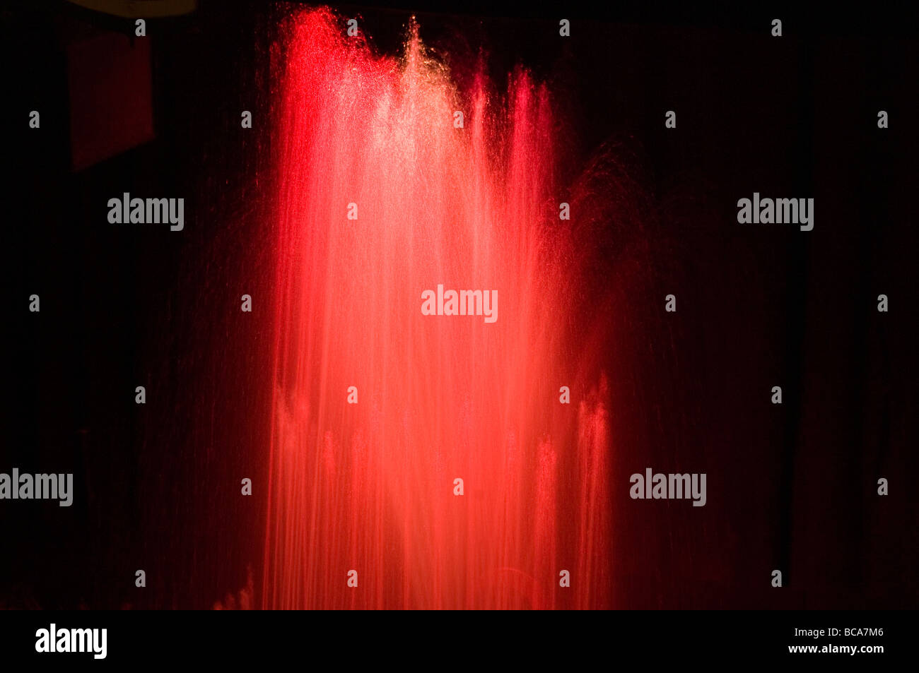 Wasser-Brunnen beleuchtet mit roten Lichtern auf langsame Verschlusszeit getroffen Stockfoto