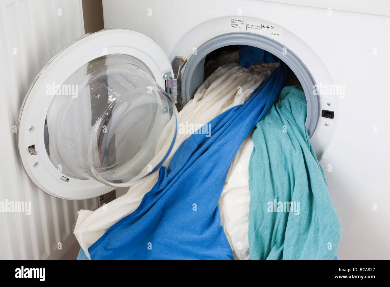 Frontlader-Waschmaschine mit Kleidern in offene Tür Stockfoto