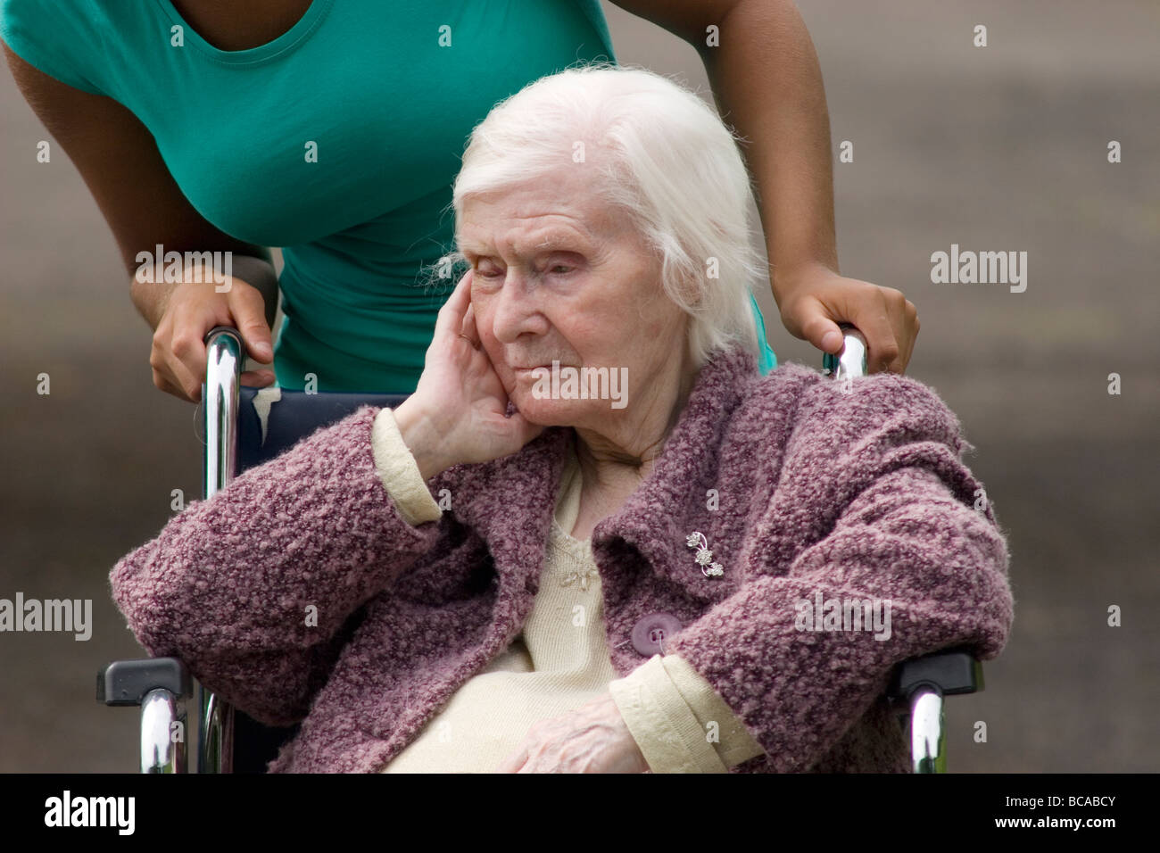 Unglücklich geriatrische Dame im Rollstuhl durch Frau geschoben Stockfoto