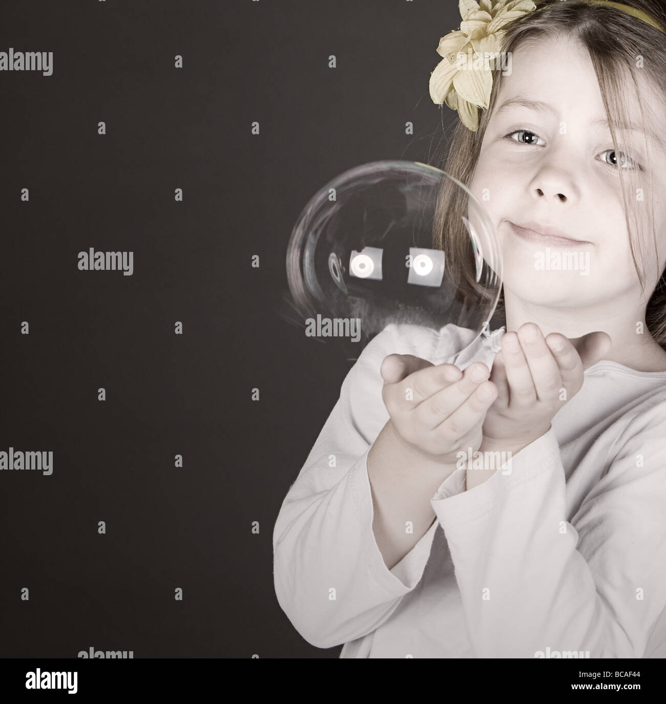Schuss von einem niedlichen kleinen Mädchen fangen eine platzende Blase Stockfoto