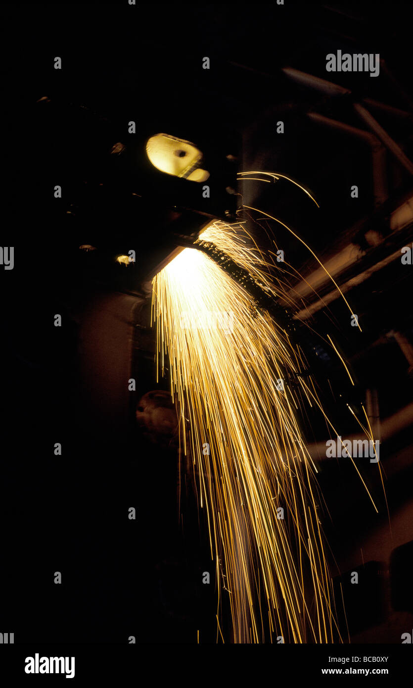 Funken fliegen von den Arbeitern im Inneren des Rumpfes ein stillgelegtes Super Tanker. Stockfoto