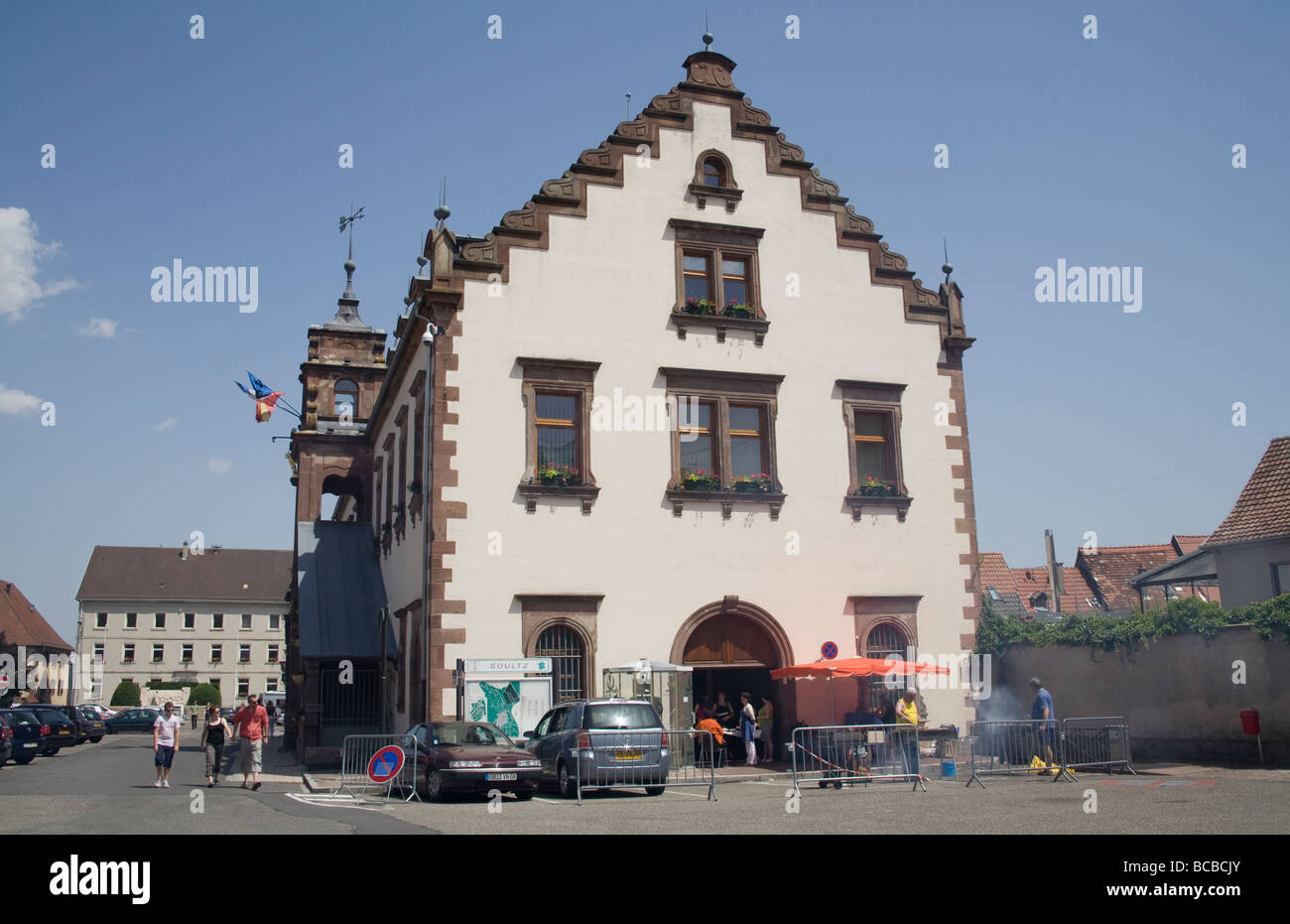 Soultz Elsass Frankreich EU Männer tendenziell einen Grill vor dem 18thc Rathaus Stockfoto