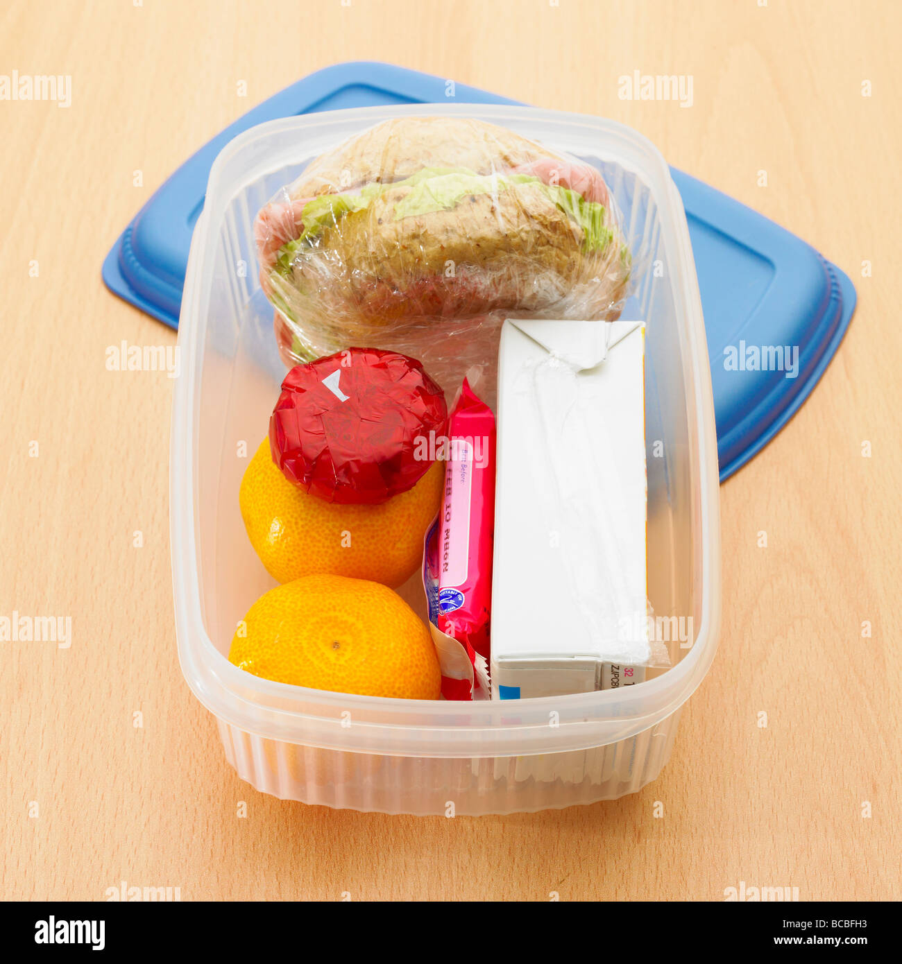 Gesunde Lunch-Box mit Vollkorn Roll, Satsumas, Mini light Käse, Orangensaft und Gebäck. Stockfoto