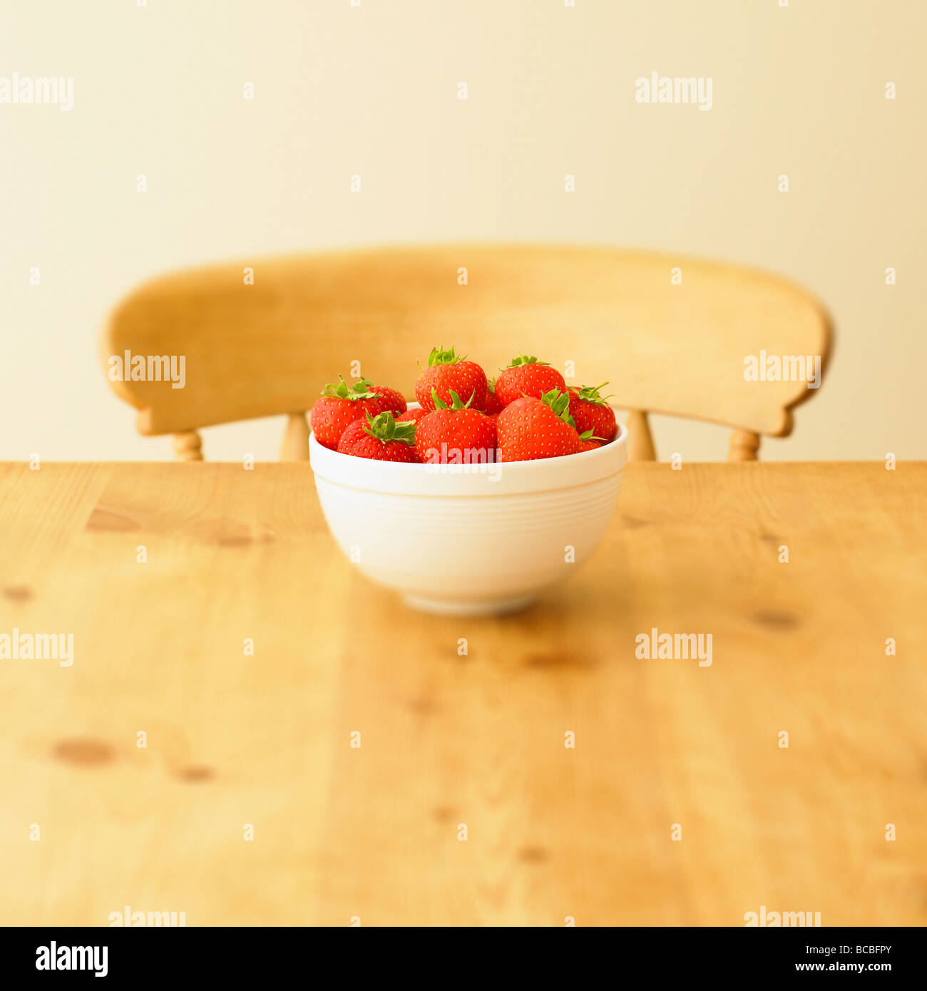 Schale mit Erdbeeren auf einem rustikalen Küchentisch. Stockfoto