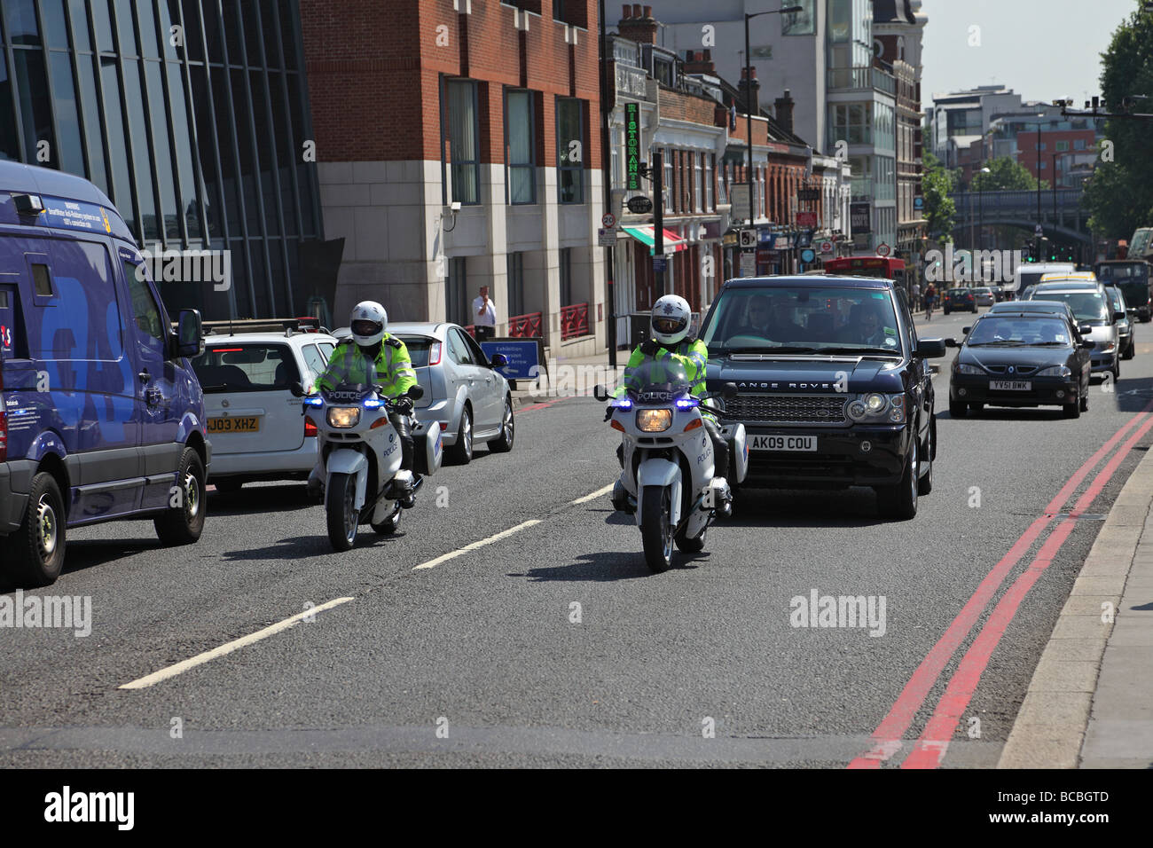 Polizei-Motorrädern eskortiert einen Range Rover in London Stockfoto