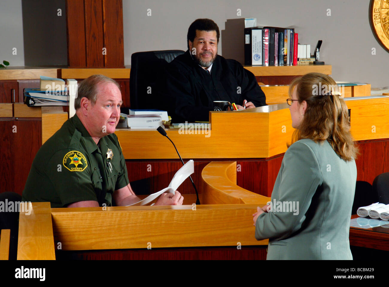 Unter dem wachsamen Auge der Afro-Amerikaner bezeugt Richter ein stellvertretender Sherrif in einem Gerichtssaal Southern California Stockfoto