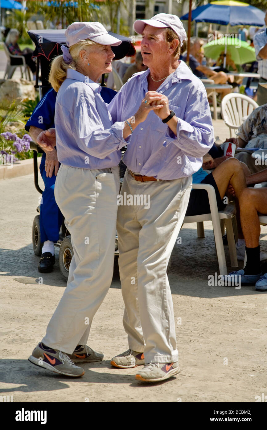 Ein identisch gekleidete paar in ihren Siebzigern tanzen zusammen bei einem Outdoor-Band-Konzert in Coronado, Kalifornien Stockfoto