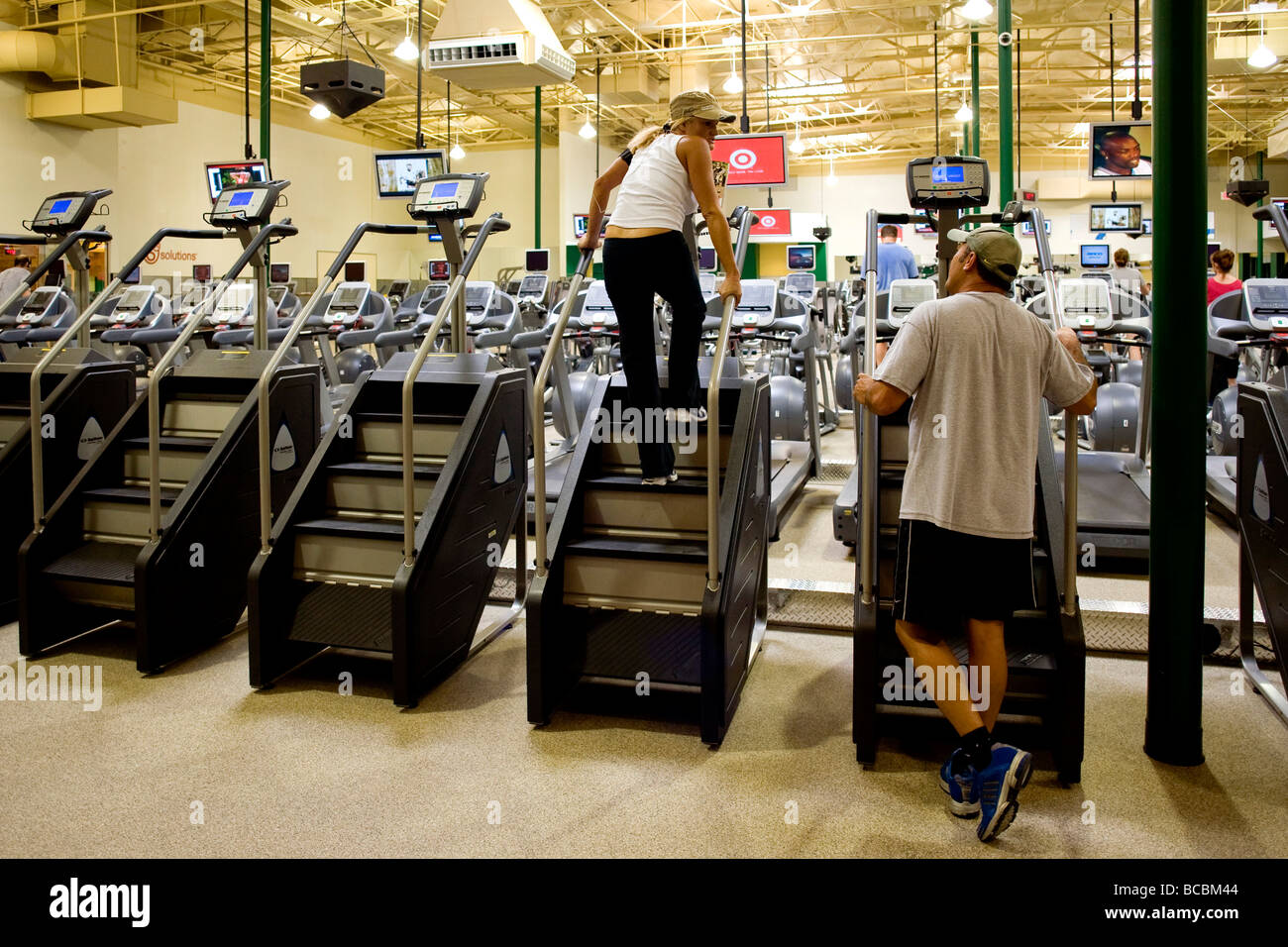 Fernsehgeräte, abgestimmt auf verschiedene Kanäle umleiten Übung Buffs in einem Southern California Fitnesscenter Stockfoto