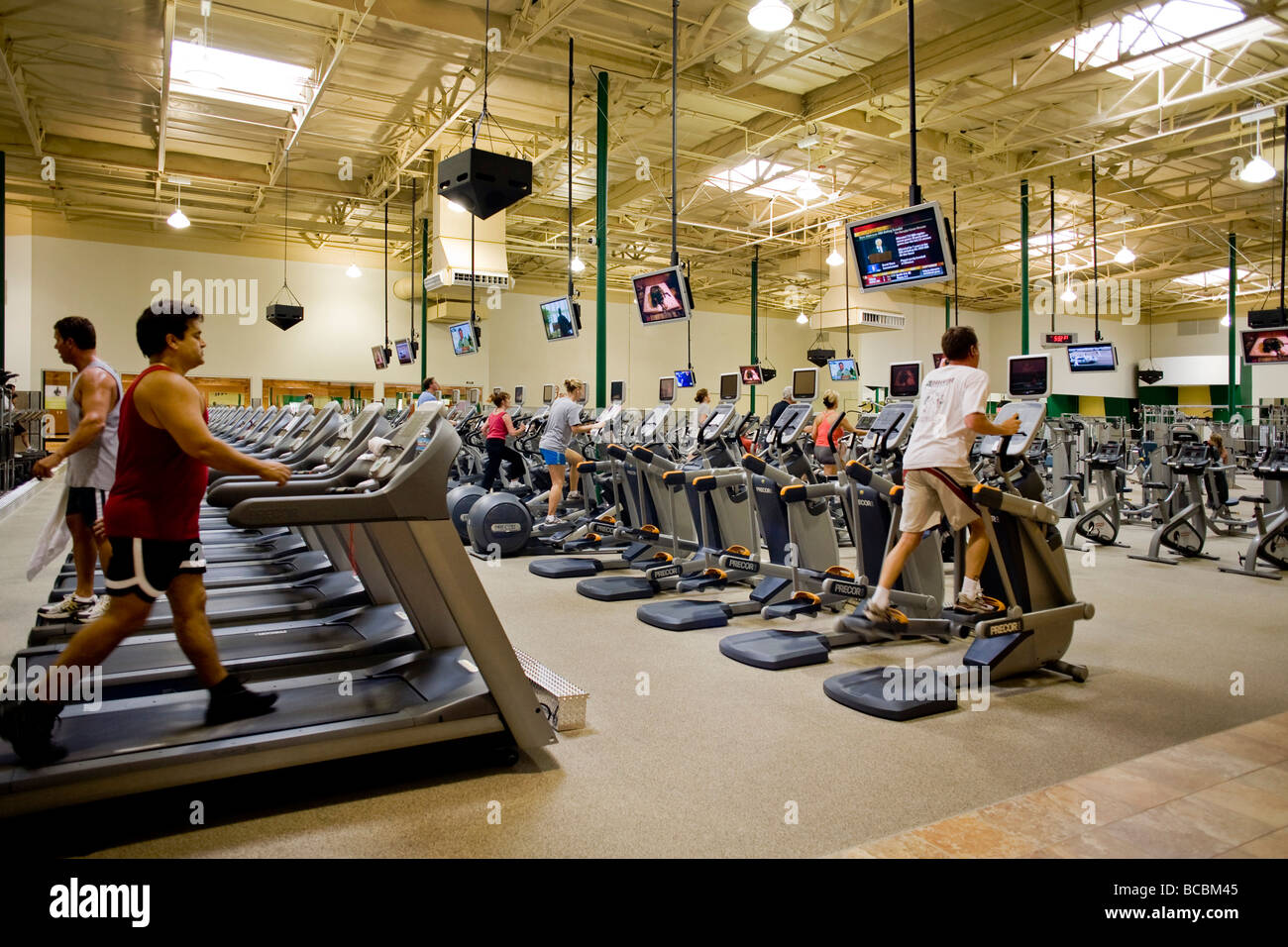 Fernsehgeräte, abgestimmt auf verschiedene Kanäle umleiten Übung Buffs in einem Southern California Fitnesscenter Stockfoto
