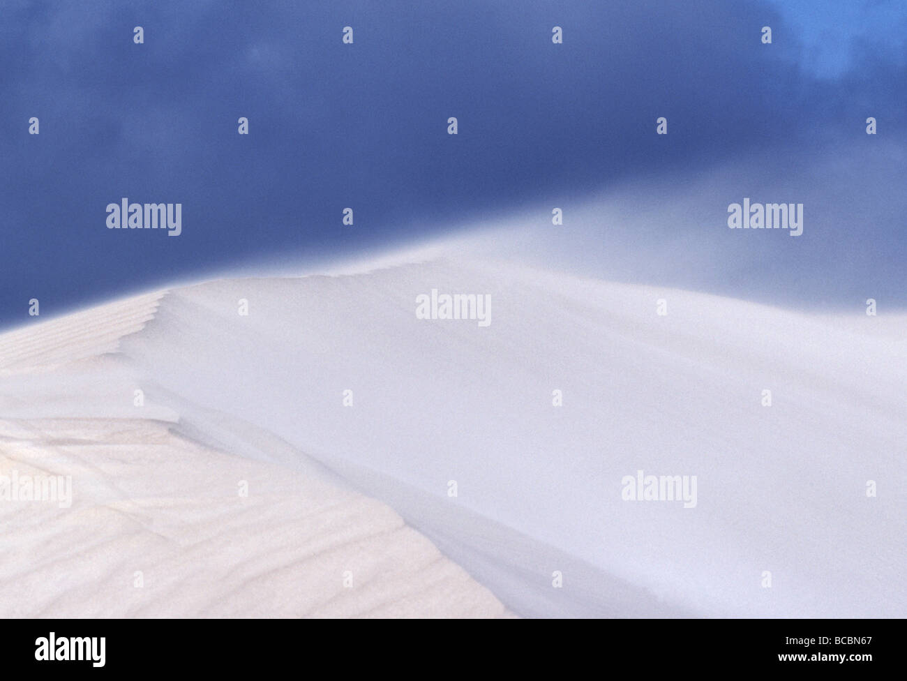 Explosion auf dem Höhepunkt einer weißen Sanddüne, wisping entfernt Sand schlängelt. Stockfoto