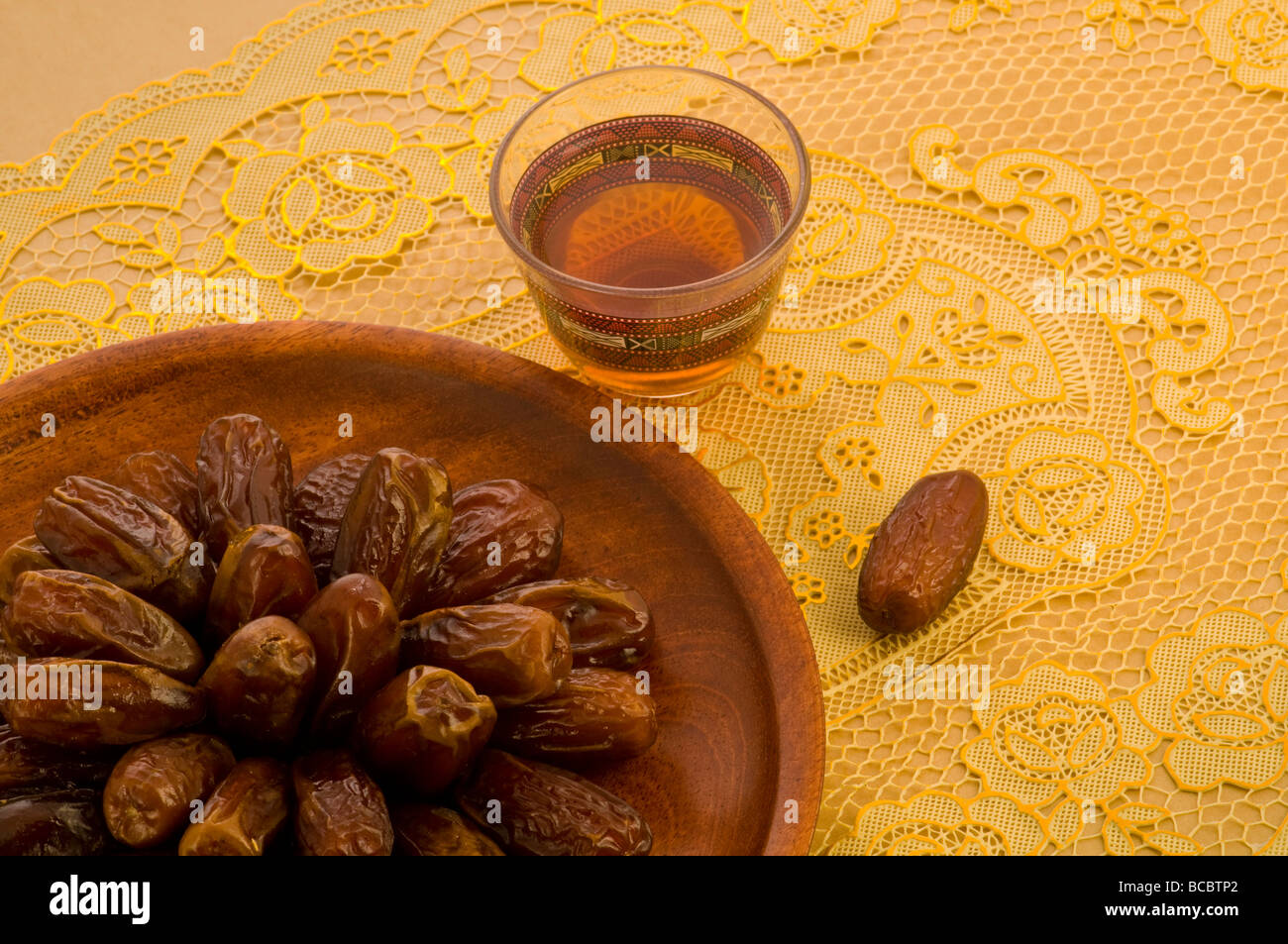 Arabischen Datumsangaben in einer hölzernen Platte mit Tasse Tee gerissen Stockfoto