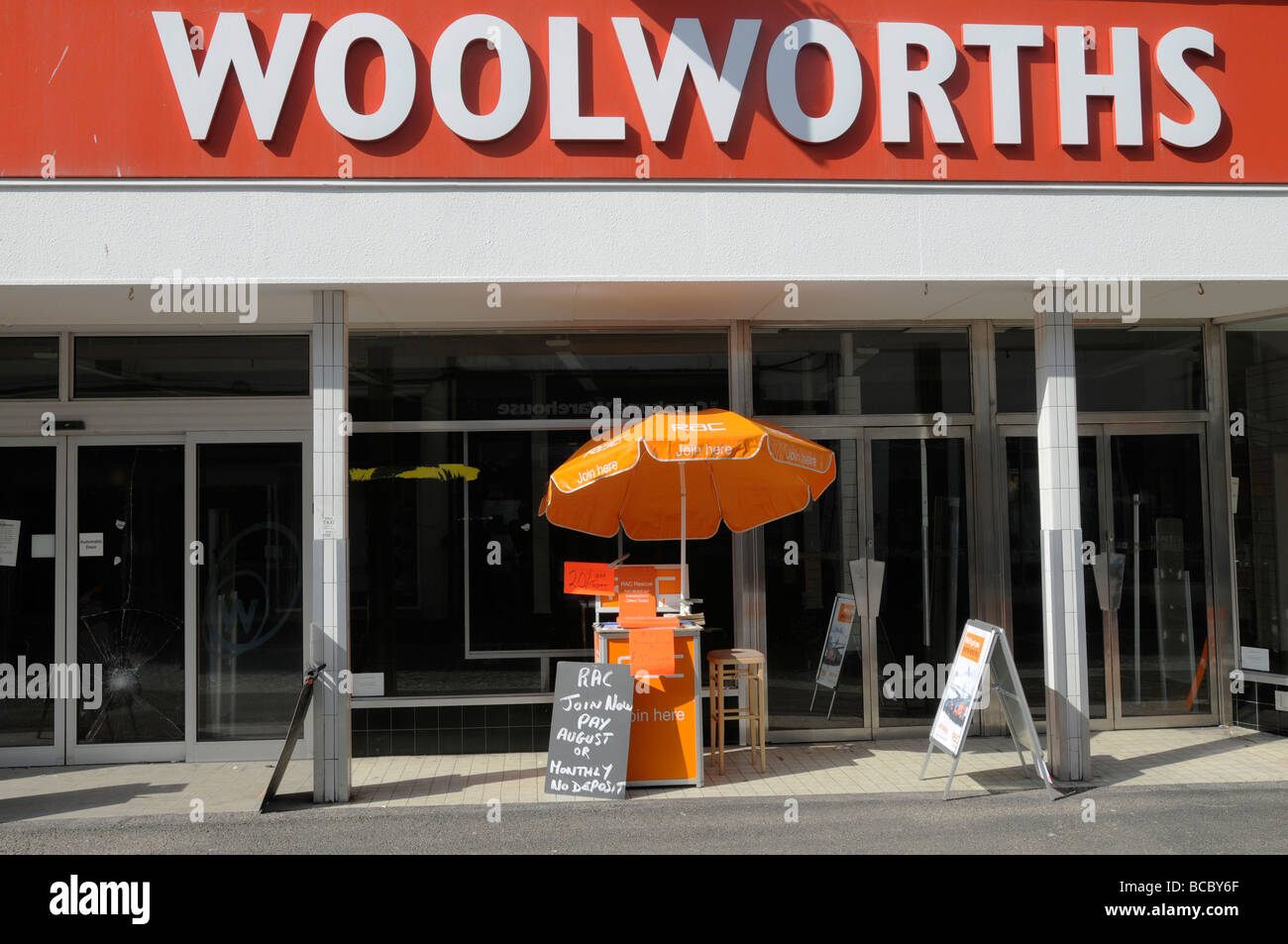 Ein RAC Verkaufsstelle drausen eine geschlossene Woolworths in Falmouth, Cornwall Stockfoto