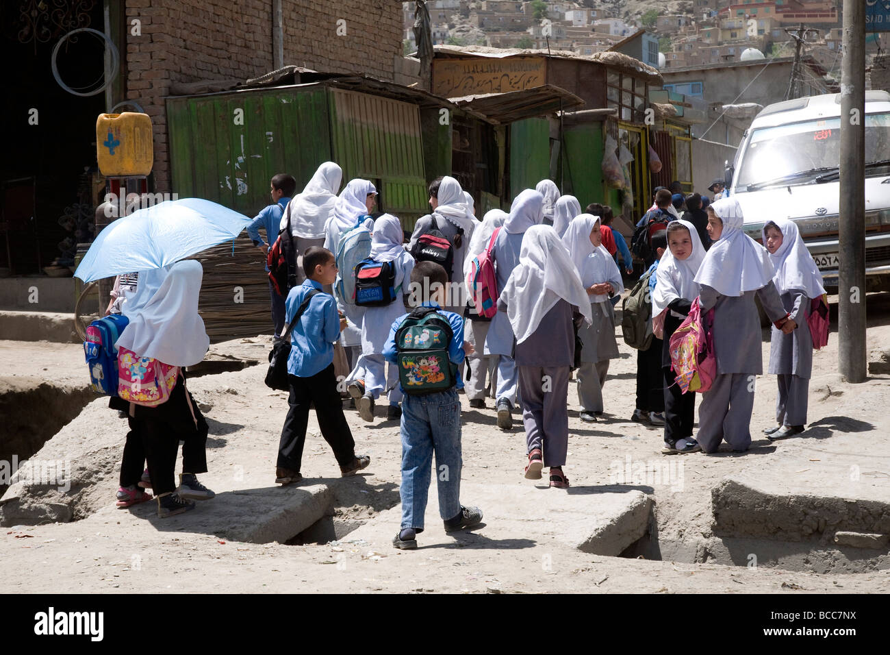 Schülerinnen und Schüler--verschleierte Mädchen und barhäuptig jungen--in einer Kabul Stadtstraße, Afghanistan Stockfoto
