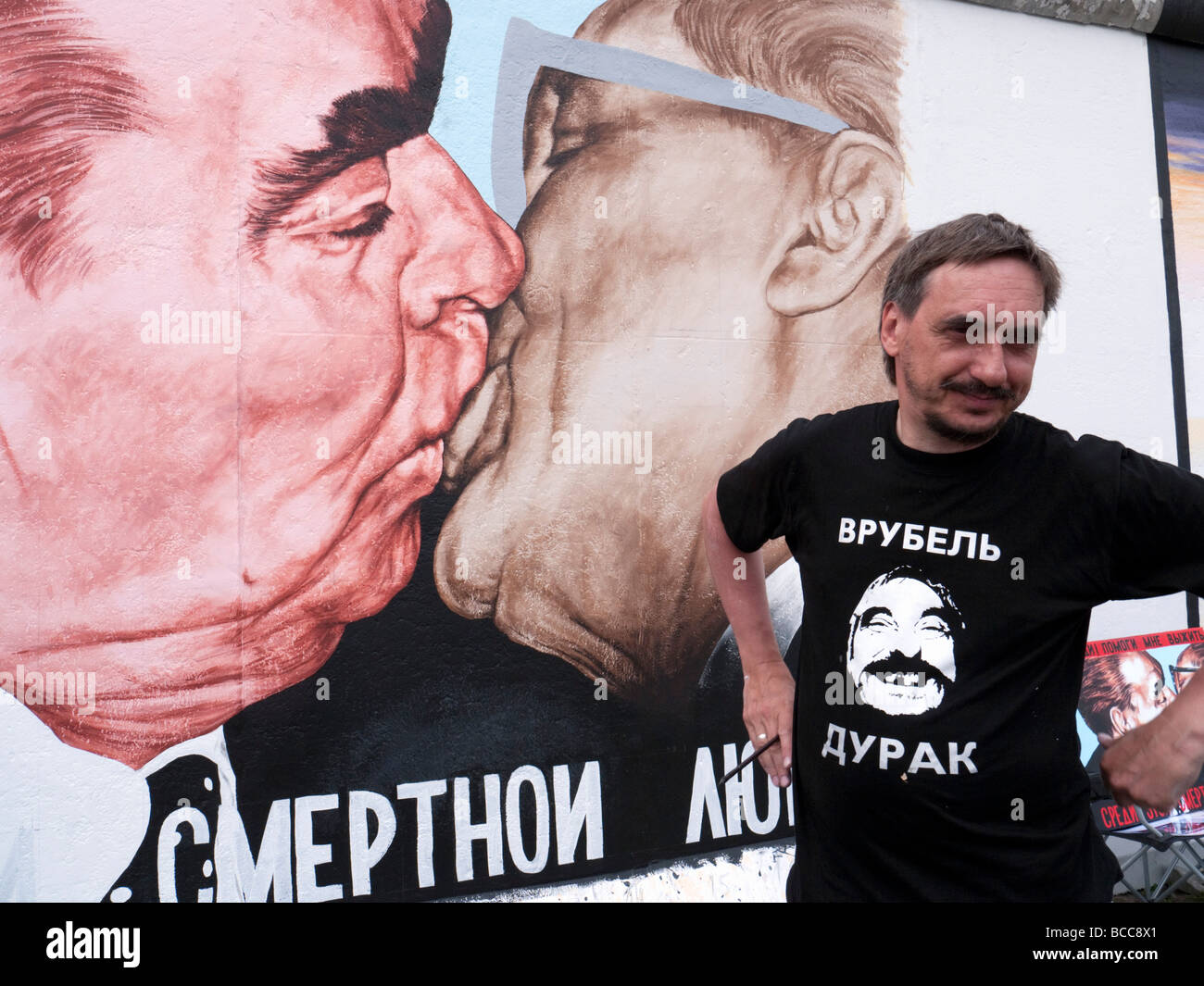 Russische Künstler Dimitry Vrubel Malerarbeiten seine berühmte original Wandbild von Breschnew Honecker auf der Berliner Mauer Juni Stockfoto